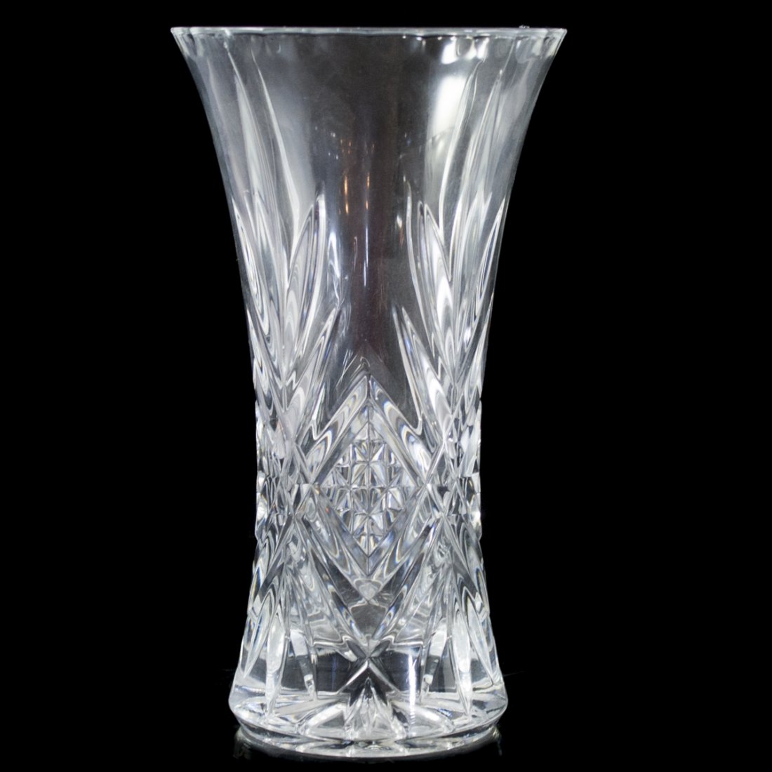 Crystal Vase: DESCRIPTION:Crystal vase with concentric diamond cuts and symetrical patterns along the body of the vase as well as indented edge work along the rim. CIRCA:20th Ct. ORIGIN:Unknown DIMENSIONS:H:11.75" 