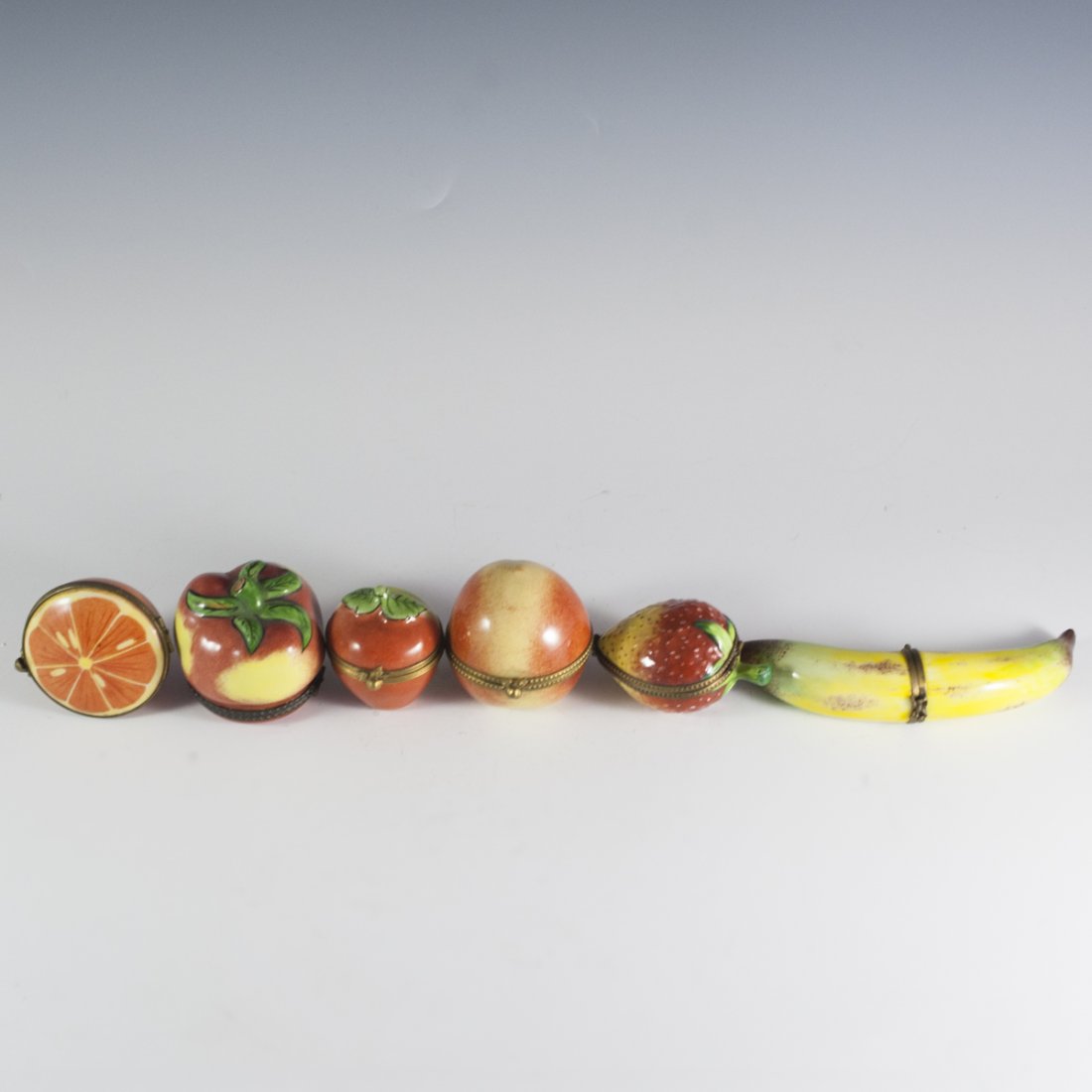 Limoges Porcelain Fruit Pillboxes: DESCRIPTION:Lot of Limges porcelain handpainted pill boxes in fruit motif. Features a strawberry, banana, orange, pear, tomato, and apple. Finished with a glossy glaze and marked: "Limoges France Pein