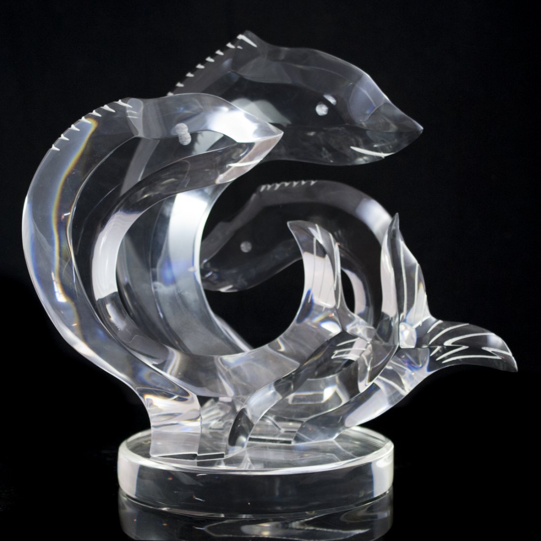 Lucite Van Teal Sculpture: DESCRIPTION: Clear lucite sculpture featuring three fish intertwined with one another. Rests on a circular base and marked: "Van Teal". Includes tall black stand that beautifully illuminates the piece