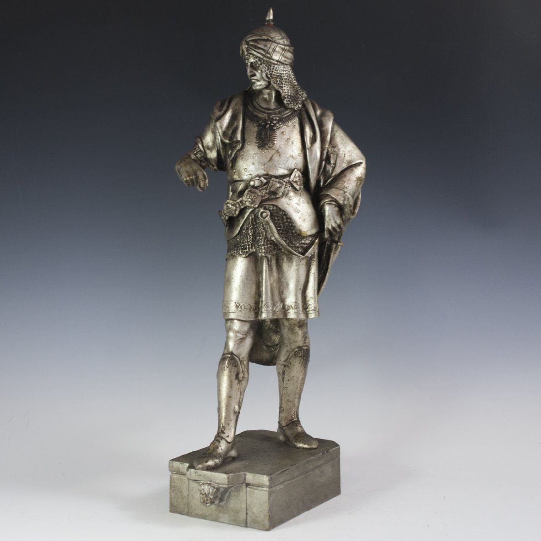 Emile Picault (French, 1833-1915) Silvered Bronze: DESCRIPTION:Silvered bronze sculpture by Emile Picault of a soldier adorned in elaborate armor and sheathing a sword behind his back and an outstretched right hand. Rests on a a bronze base and signed