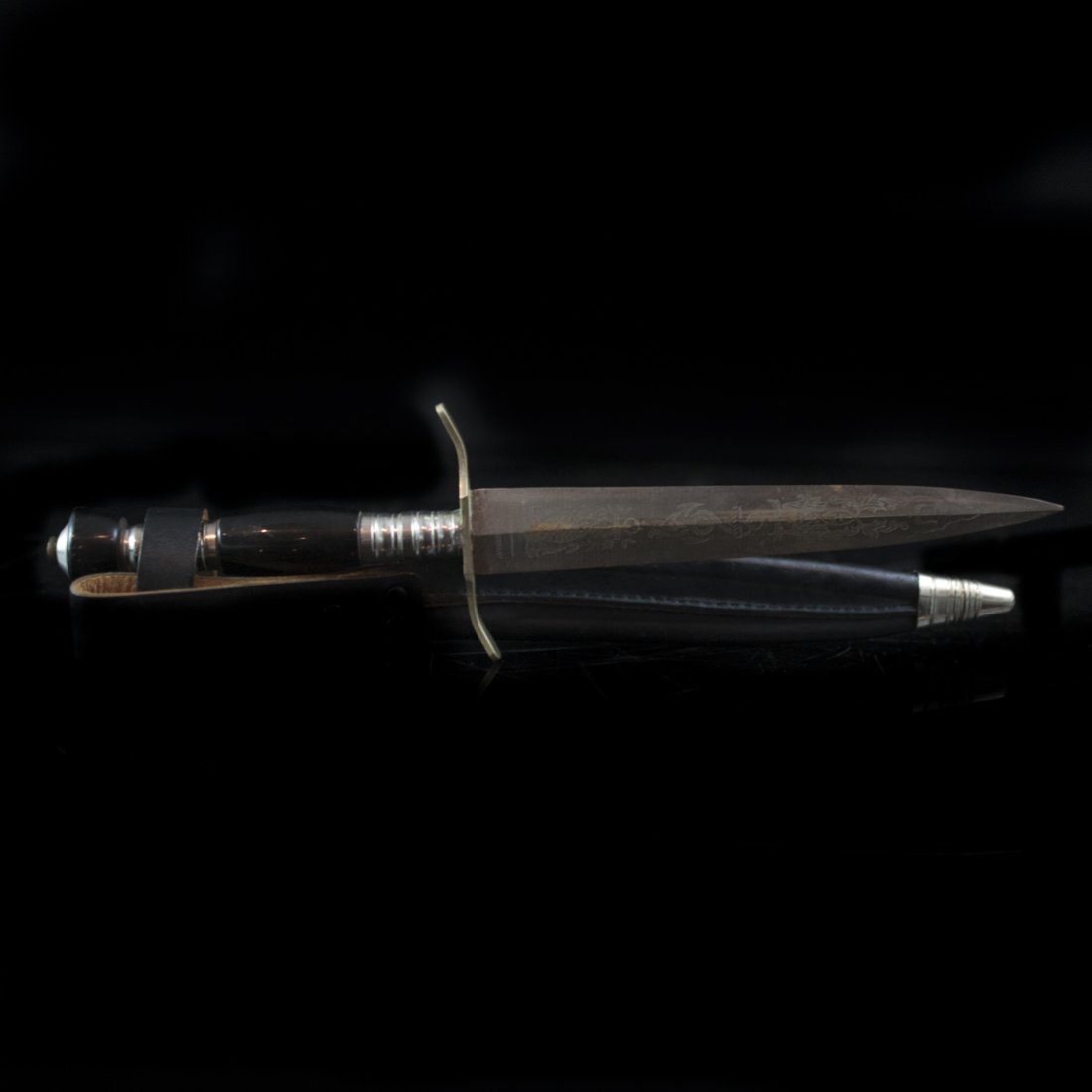 Solingen German Knife & Sheath: DESCRIPTION:German knife from Solingen. Features engraved decoration of sailor's knots, anchors, and tridents. Includes leather sheath and ebonized handles and marked:"Solingen Germany" CIRCA:20th Ct.