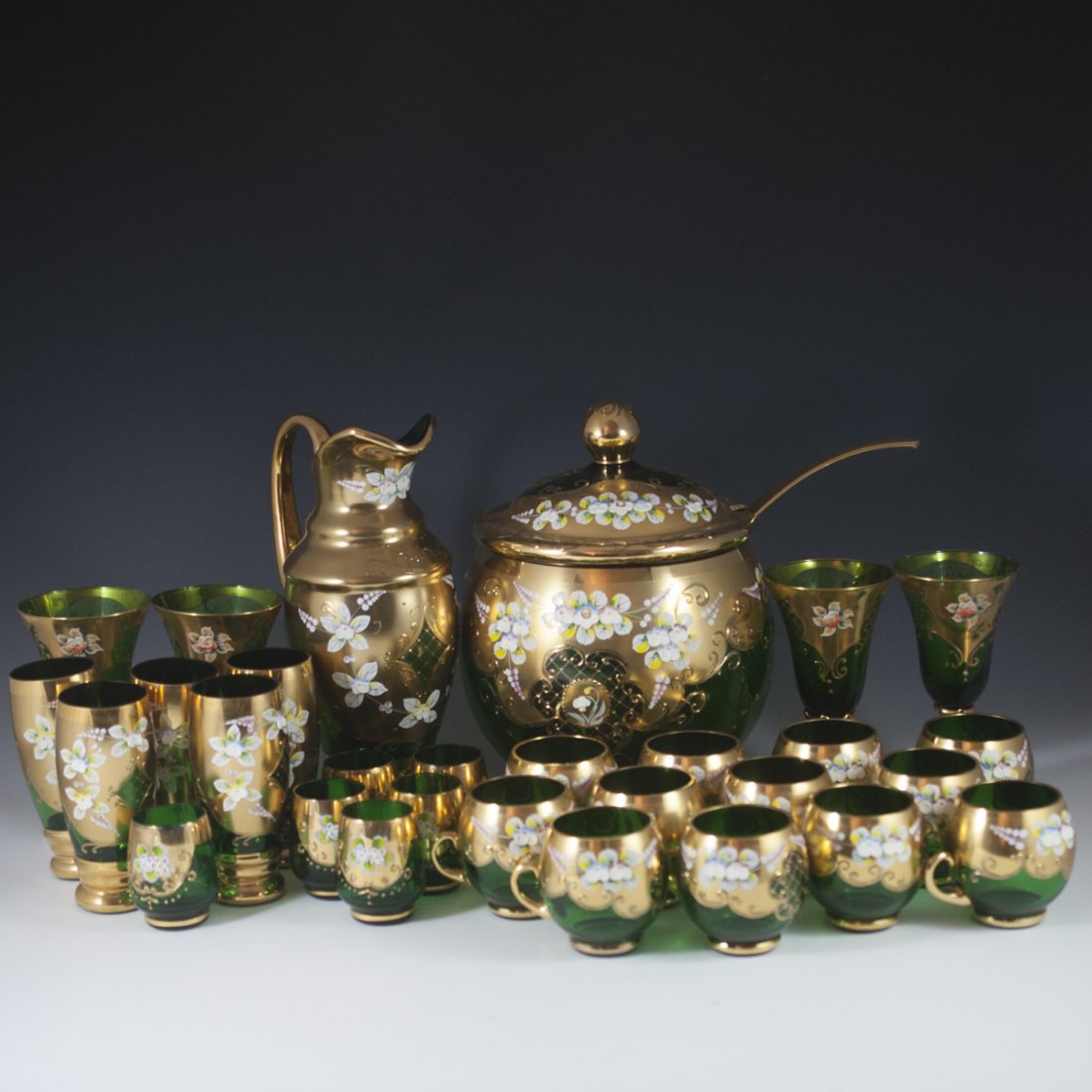 Large Enameled Gold Overlay Bohemian Glass Set: DESCRIPTION: Large Bohemian glass set. Includes an emerald green set comprising of 12 coffee cups, 5 glasses, 4 wine glasses, 6 liquor glasses, a jug, and a lidded punch bowl with a ladle. All pieces