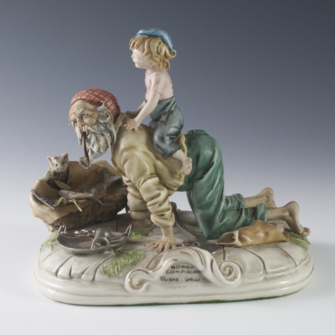 Capodimonte Tiziano Galli "Nonno Complacente" Figurine: DESCRIPTION:Capodimonte figurine by Tiziano Galli titled:"Nonno Complacente" or "Complacent Grandfather". Features a grandfather on his hand and knees giving his grandson a ride while smoking a pipe w