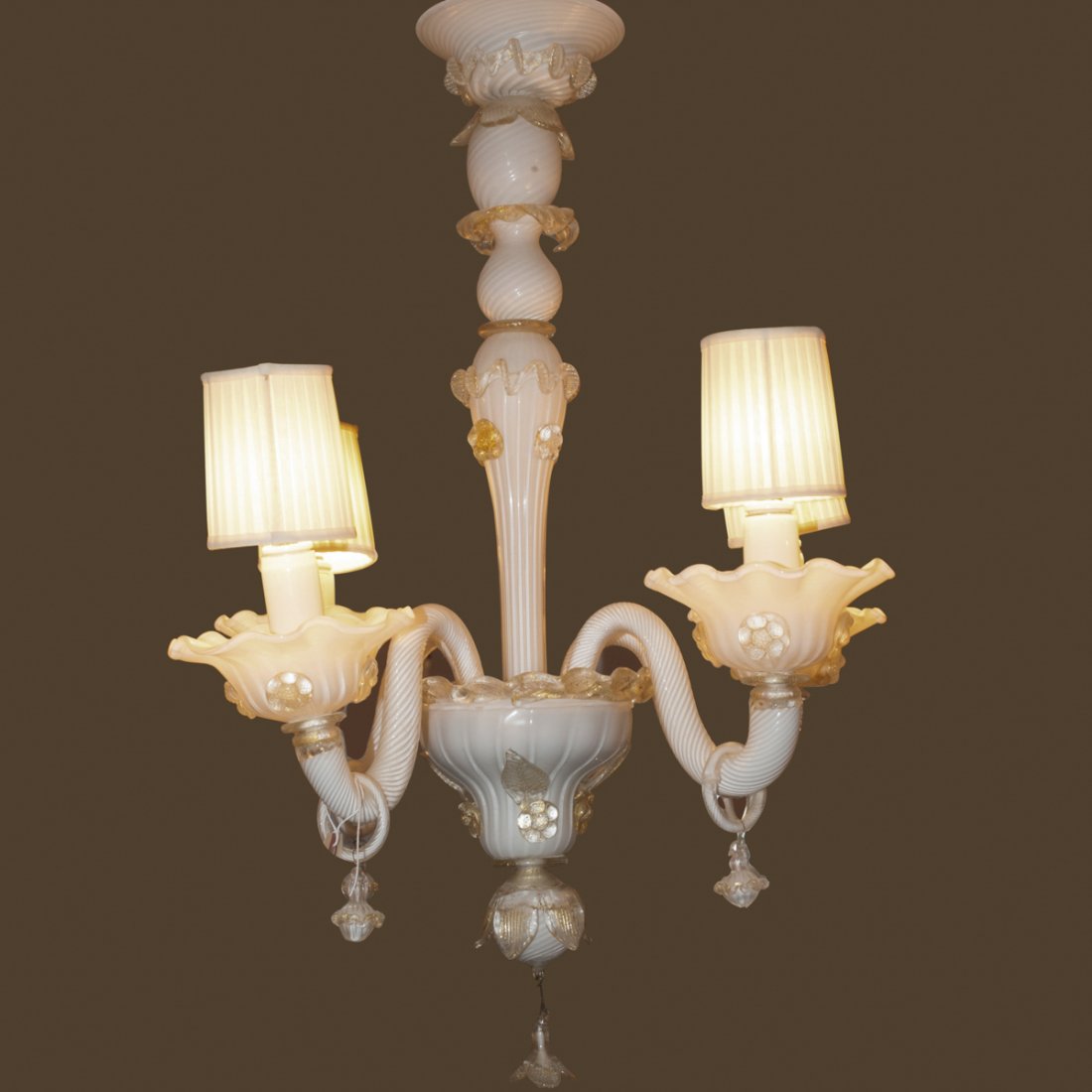 Murano Glass Chandelier: DESCRIPTION:Murano glass chandelier comprising of a center glass stem with a milky white hue and spiraling decoration embellished with flower petals and rosettes. Finished with four curved spiraling a