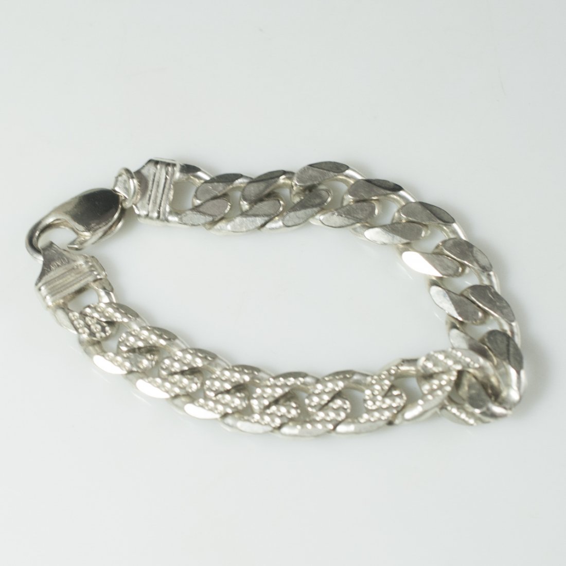 Sterling Cuban Link Bracelet: DESCRIPTION:Sterling bracelet comprised of thick cuban links with circular designs. Marked:"925 Italy" CIRCA:20th Ct. ORIGIN:Italy DIMENSIONS:L:7.5" Total Weight:34 grams CONDITION:Great condition. Fu