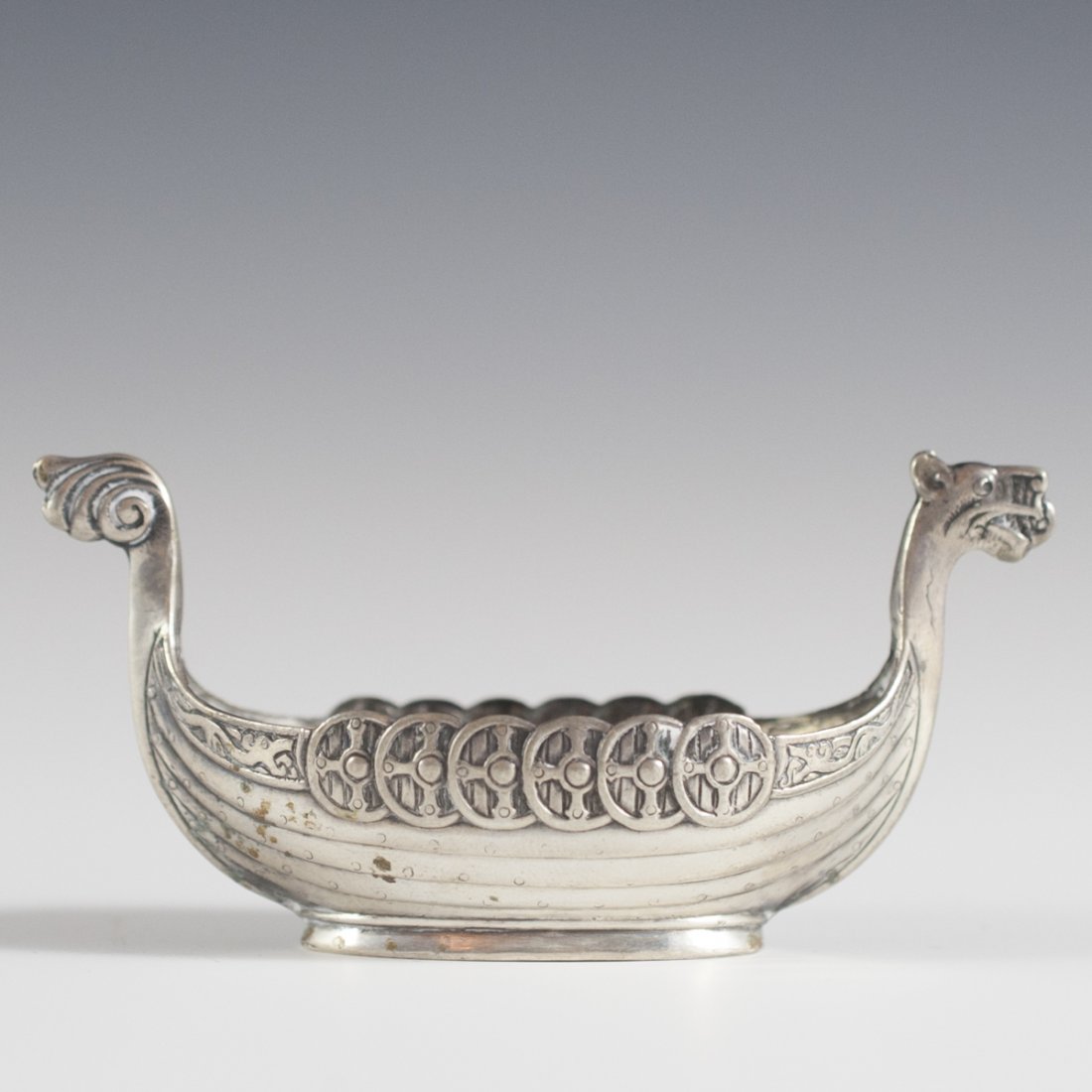 Sterling Viking Salt Cellar: DESCRIPTION:Sterling salt cellar in the motif of a dragonheaded viking ship with shields hanging off the side and an image of the "North Cape" mountain side along the bottom. Marked:"Nordkap Norge 925