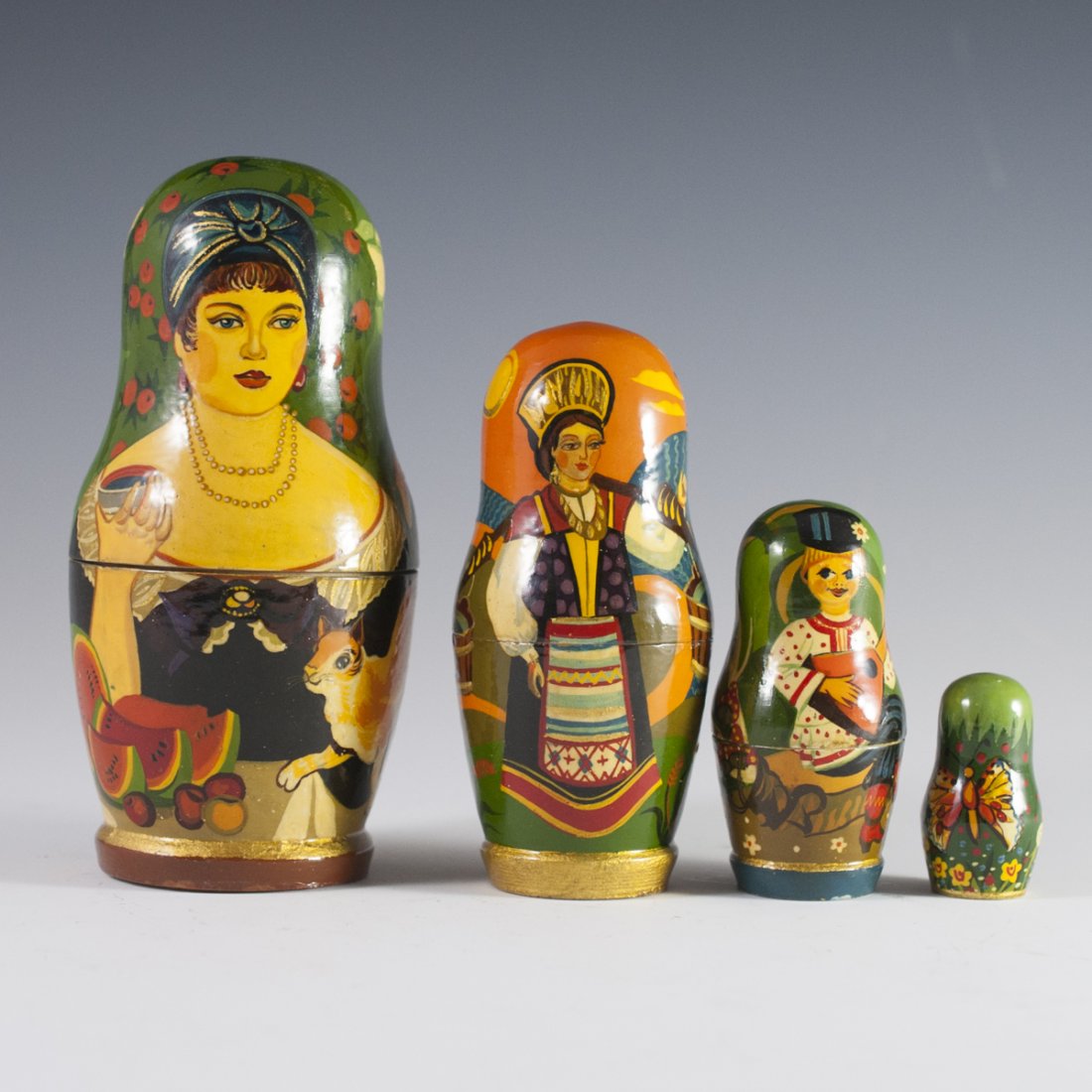 Vintage Russian Nesting Doll: DESCRIPTION: A vintage Russian nesting doll with handpainted renderings of a bejewled art Deco era woman drinking wine and further traditional scenes. Signed on the bottom in Russian. CIRCA: 20th Ct.