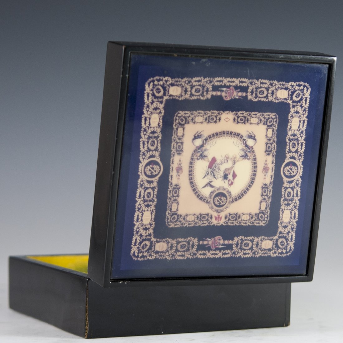 Vintage Gianni Versace Jewelry Box: DESCRIPTION: A vintage lacquered Gianni Versace jewelry box. Features a rendering of soaring mythical figures on horse drawn chariots enveloped with traditional Versace floral motif. Marked:"Gianni Ve