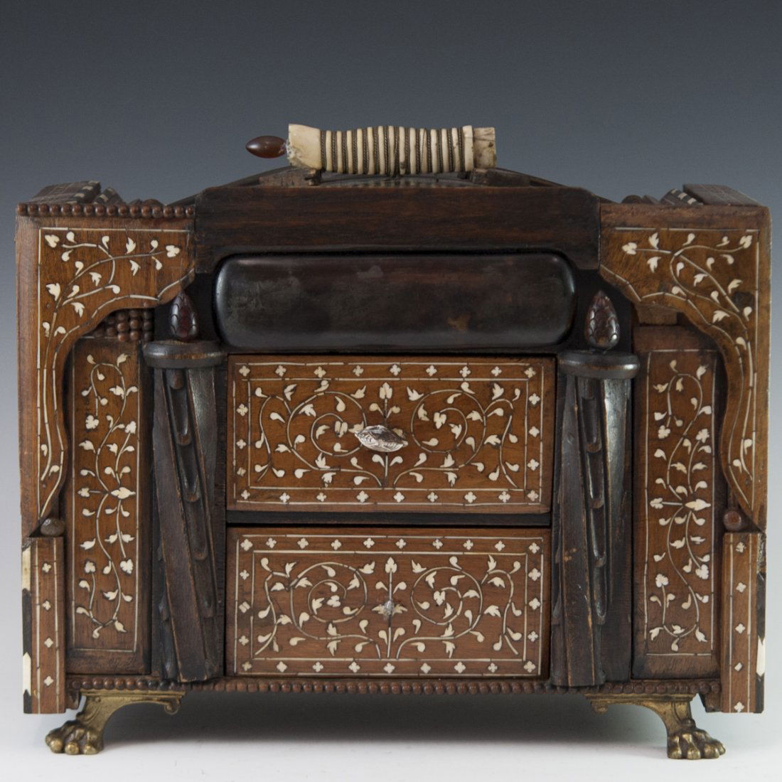 Attributed to Carlo Bugatti (Italian 1856-1940): DESCRIPTION: A cabinet Box attributed to Carlo Bugatti. Features inlaid bone in scrolling Oriental floral motif throughout the box and along the two pull drawers fitted with carved figural bone handle