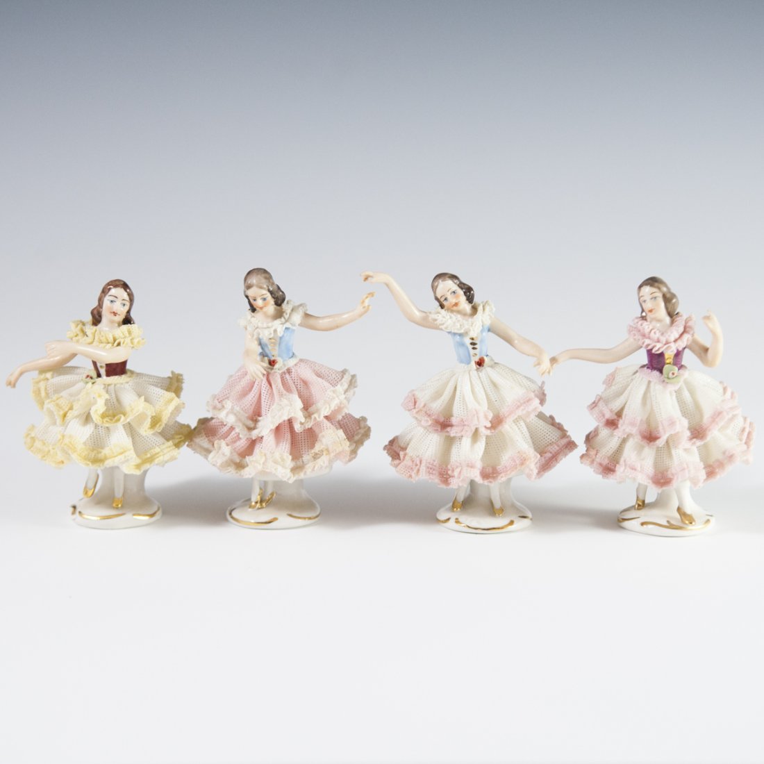 Wilhelm Rittirsch Dresden Porcelain Ballerinas: DESCRIPTION: Lot of four Dresden porcelain ballerinas. All are seen dancing, wearing elegantly folded, perforated dresses. Marked on bottom:"Dresden Art Made in Germany" along with Wilhelm Rittirsch p