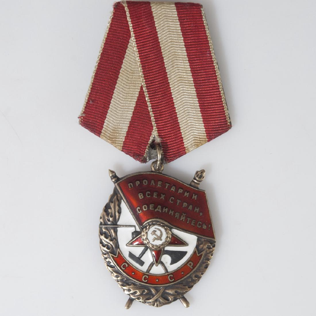 Soviet Order of the Red Banner Medal: DESCRIPTION: A Soviet Order of the Red Banner medal. Comprised of silver, this medal features white enamel enveloping the center hammer and sickle along with red enamel finishes. Finished with a white