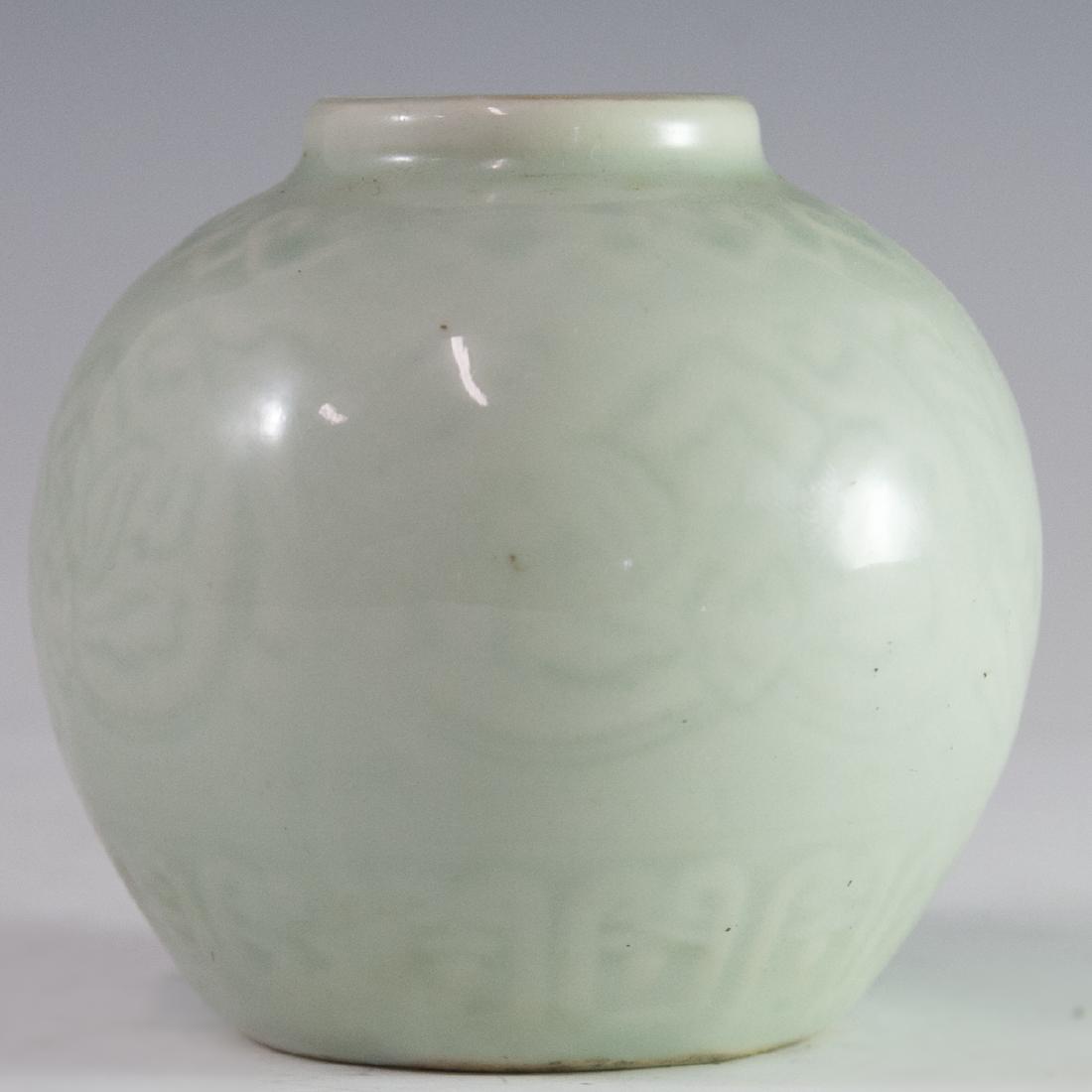 Antique Chinese Celadon Vase: DESCRIPTION: An antique Chinese celadon vase. Features a rotund shape with embossed embellishment of floral motifs and traditional Chinese patterns. Marked on bottom with an underglaze stamp. CIRCA: 1