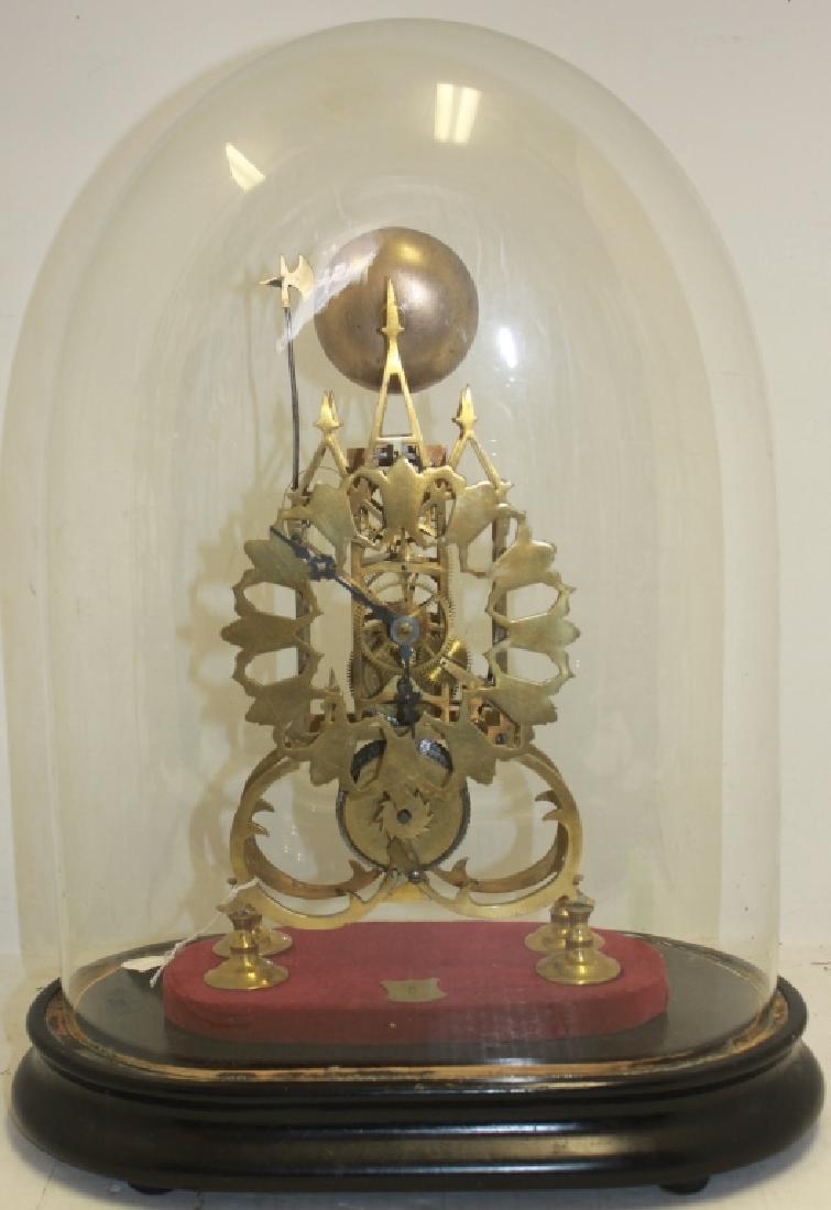 19TH C BRASS SKELETON CLOCK, FUSEE MOVEMENT,: CATHEDRAL STYLE WITH PENDULUM AND KEY, GLASS DOME WITH WOODEN BASE. CLOCK 14 1/2" HIGH, TOTAL HEIGHT WITH DOME 20 1/2". GOOD REPAIR TO BRASS FOOT AND FRAME. NOT GUARANTEED TO WORK.