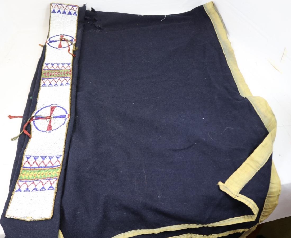 19TH C SIOUX BEADED BLANKET STRIP ON BLUE TRADE: CLOTH. BLANKET SHOWS DAMAGE AND HOLES, 74" X 54". SEE OUR OTHER NATIVE AMERICAN ITEMS.