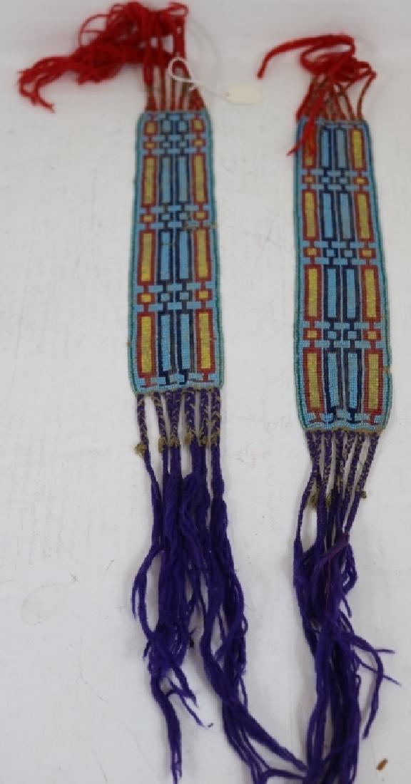 2 LATE 19TH C WINNEBAGO MEN'S GARTERS, BEADED: GEOMETRIC DESIGN, POSSIBLY RESTORATION TO FRINGE. 24" LONG X 2 1/2" WIDE.