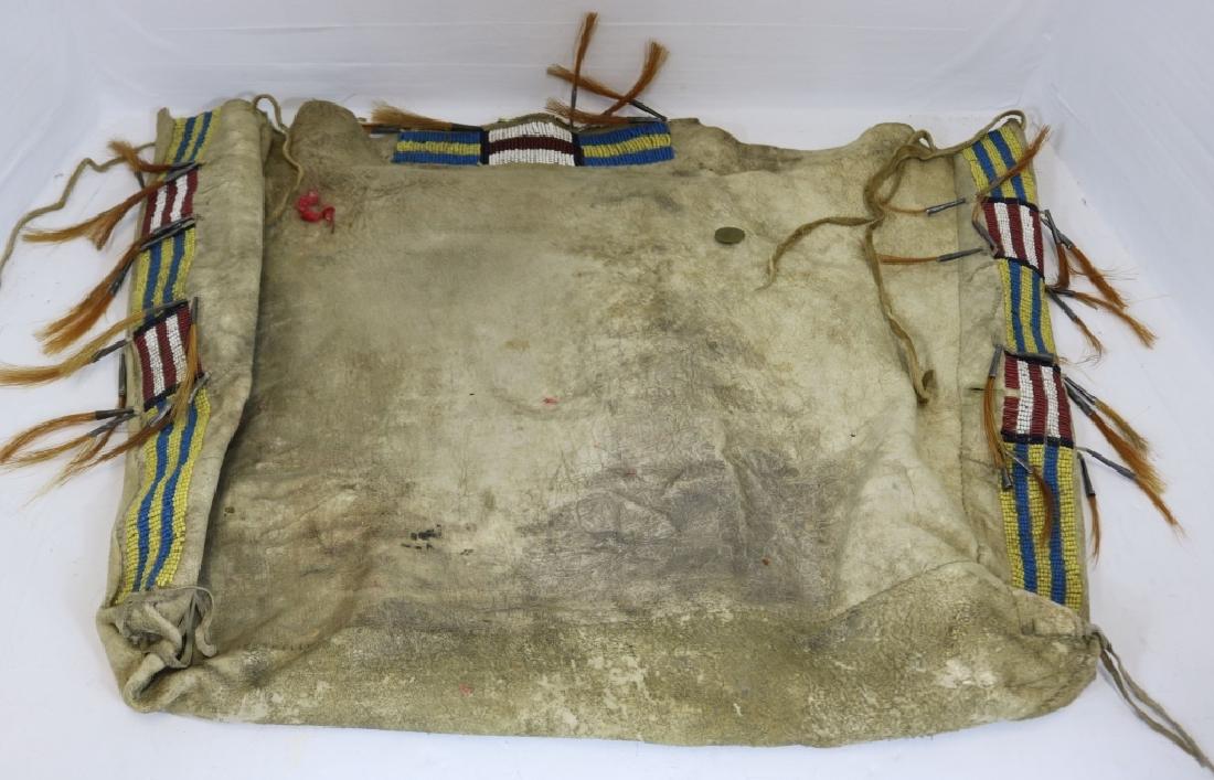 19TH C CHEYENNE, POSSIBLE BAG, PONY AND SEED: BEADED DECORATION, TIN CONE AND HORSEHAIR ATTACHMENTS. 2 BRASS BUTTONS WITH SUPPLE LEATHER. LEATHER SHOWS 2 SMALL TEARS. 16" X 20" X 2 1/2".