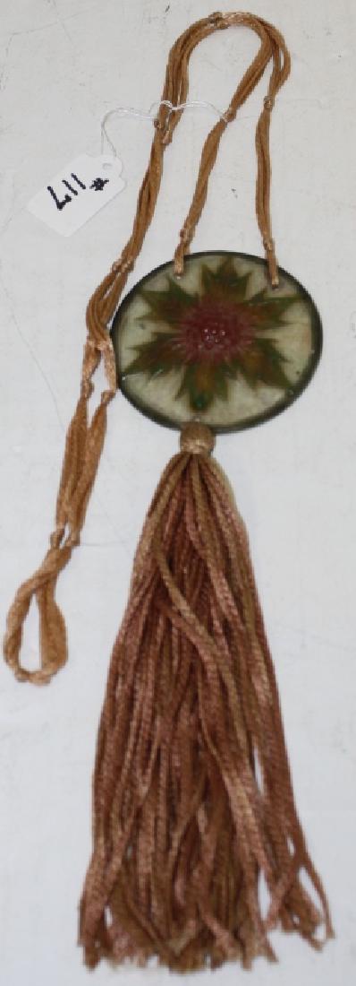 G. ARGY-ROUSSEAU, PATE-DE-VERRE ART GLASS: PENDANT WITH SILK CORD, CIRCA 1910. ROUND WITH LEAF DESIGN. 2 1/2" DIAMETER, 24" LONG WITH TASSEL AND NECKLACE.