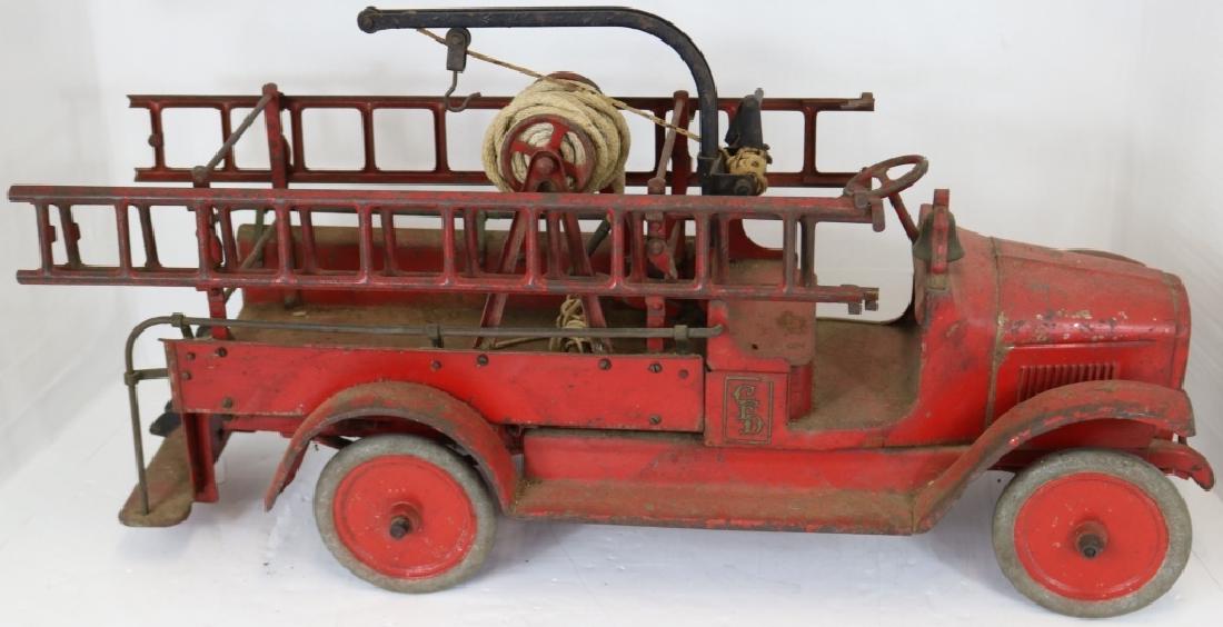 ANTIQUE CAST IRON BUDDY L FIRE TRUCK WITH: ORIGINAL LADDERS. 25 1/2" LONG, 12 1/2" HIGH, 8" WIDE. ORIGINAL WORN PAINTED FINISH.