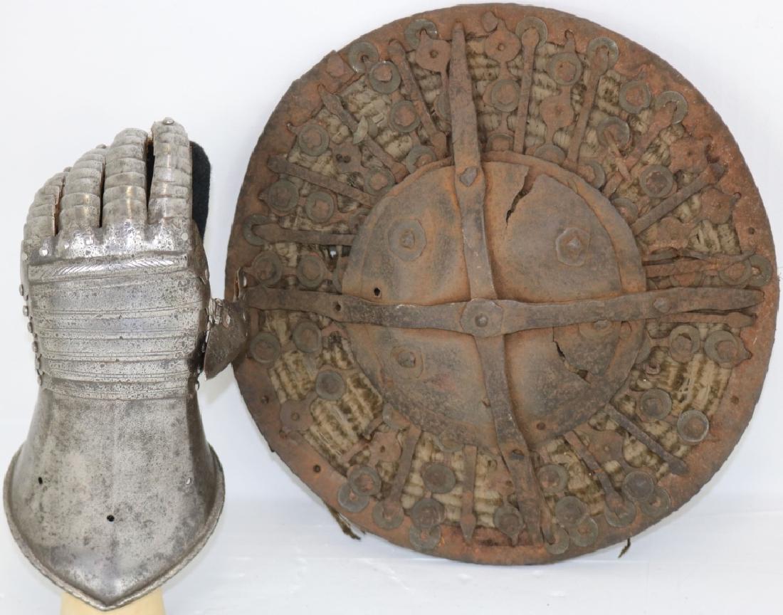 16TH C GERMAN LEFT HANDED GAUNTLET WITH FULLY: ARTICULATED FINGERS, UPPER FINGERS AND UPPER THUMB WITH NEW LEATHER UNDERNEATH, 7" HIGH X 4 1/2" WIDE. ALONG WITH AN ANCIENT SCOTTISH SHIELD OR TARGUS, WROUGHT IRON AND BASKETRY CONSTRUCTION, 11" DIAM