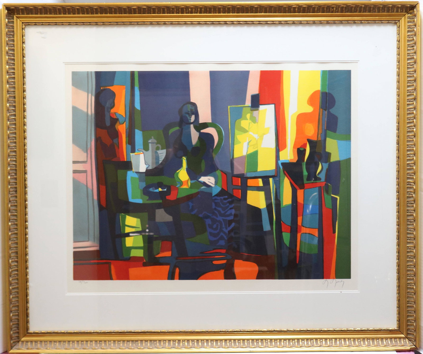 MARCEL MOULY (1918-2008, PARIS, IMPRISONED BY THE: GERMANS IN WWII, EXHIBITED IN NUMEROUS EUROPEAN MUSEUMS) LIMITED EDITION COLORED LITHOGRAPH, DEPICTING A SEATED FEMALE FIGURE BY AN EASEL. SIGHT SIZE 23 1/2" X 29 1/2", WITH MODERN GOLD GILT FRAME 35