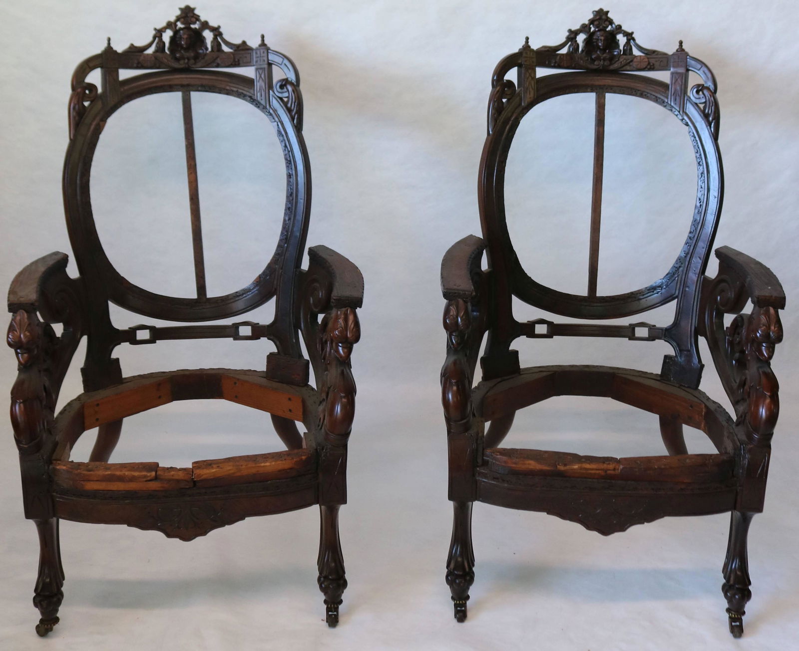 PAIR OF ORNATELY CARVED VICTORIAN ARMCHAIR: FRAMES. WALNUT. RENAISSANCE REVIVAL. CARVED GRIFFIN HEADS AT THE ARMS AND A JENNY LINDE HEAD AT TOP CREST. ANIMAL FEET. 46 1/2" HIGH, 29 1/4" WIDE, 26" DEEP. REFINISHED.