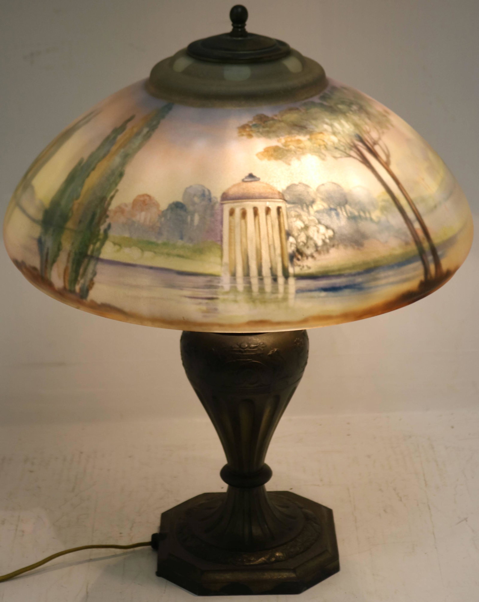 EARLY 20TH CENTURY PAIRPOINT TABLE LAMP. HAND: DONE REVERSE PAINTED LANDSDOWNE SHADE, SAN SOUCI. ARTIST SIGNED: H BISHOP. 20" HIGH, 15" DIAMETER.