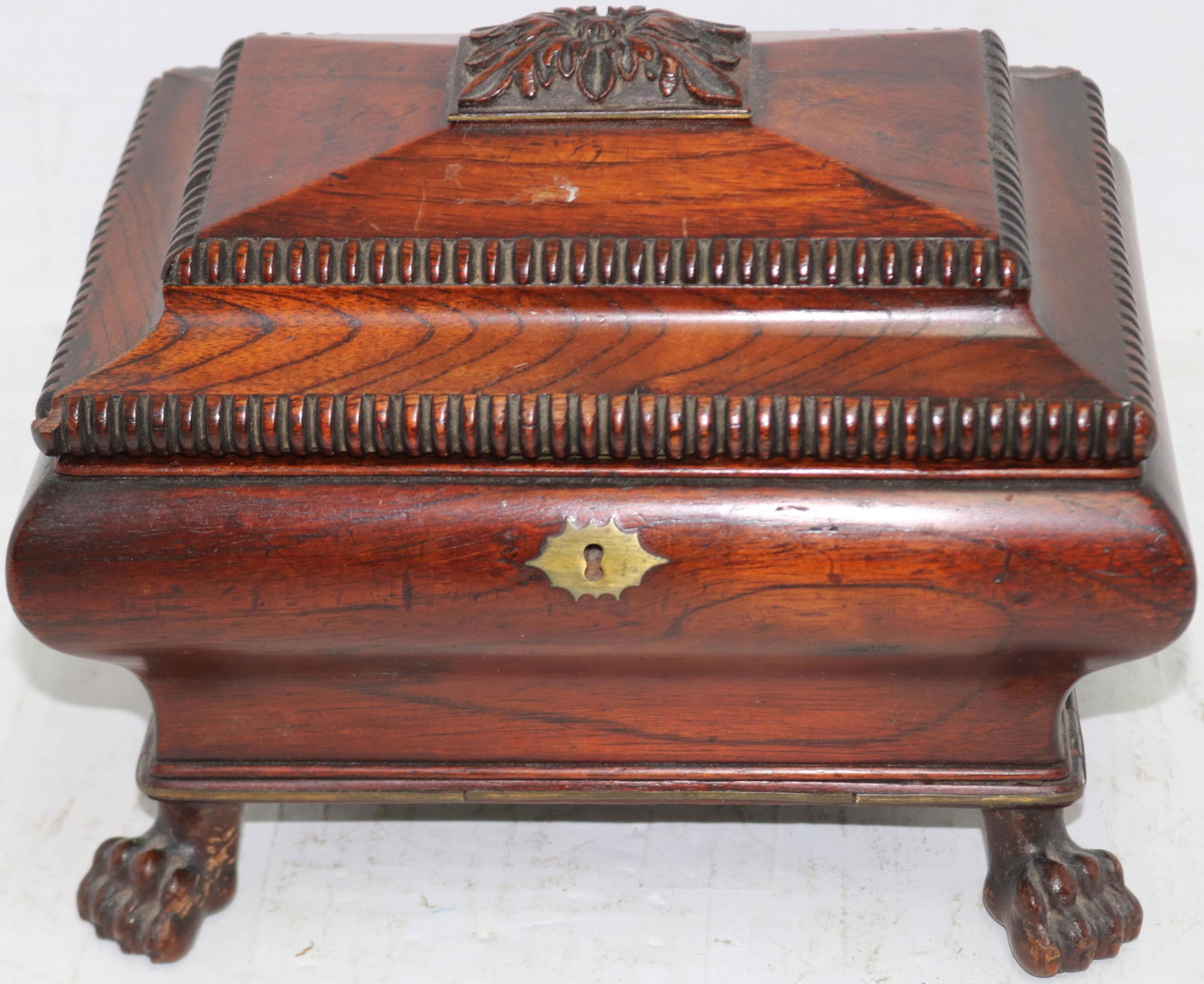 EARLY 19TH CENTURY WALNUT LIFT TOP SEWING BOX,: SARCOPHAGUS FORM WITH ANIMAL FEET. INTERIOR WITH TAFFETA TOP. TRAY INSIDE. BRASS INLAY TO BASE. 8 1/2" HIGH, 10" WIDE, 7 1/2" DEEP. CLEAN ORIGINAL FINISH.