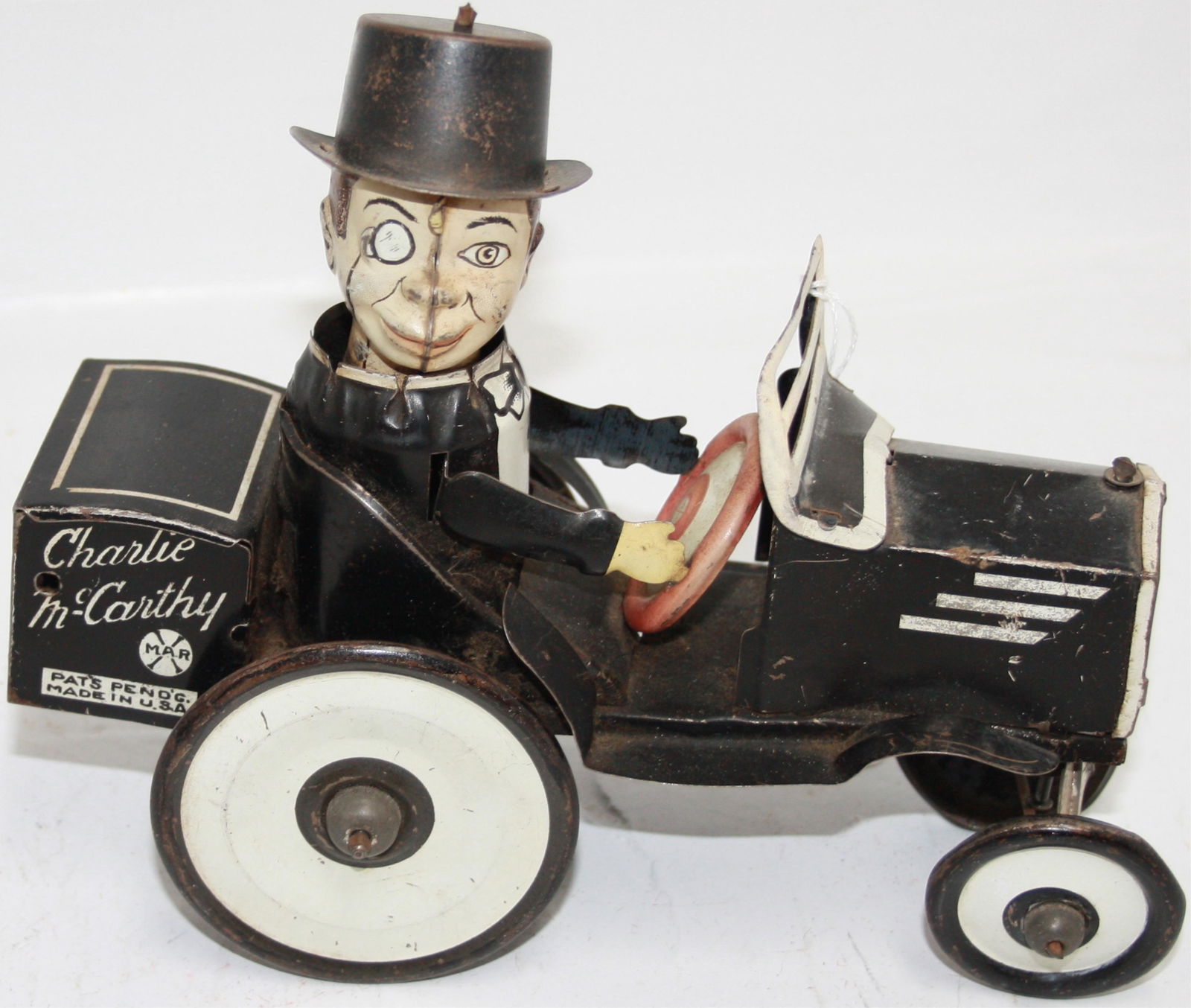 MARX TIN LITHOGRAPH CHARLIE MCCARTHY WIND-UP TOY: CAR AND DRIVER. HIS HEAD SPINS 360 DEGREES, GOOD ORIGINAL PAINT, MINOR SCRATCHES. APPEARS TO BE IN WORKING CONDITION. 7 1/2" LONG, 6 3/4" HIGH, 3 1/4" WIDE.