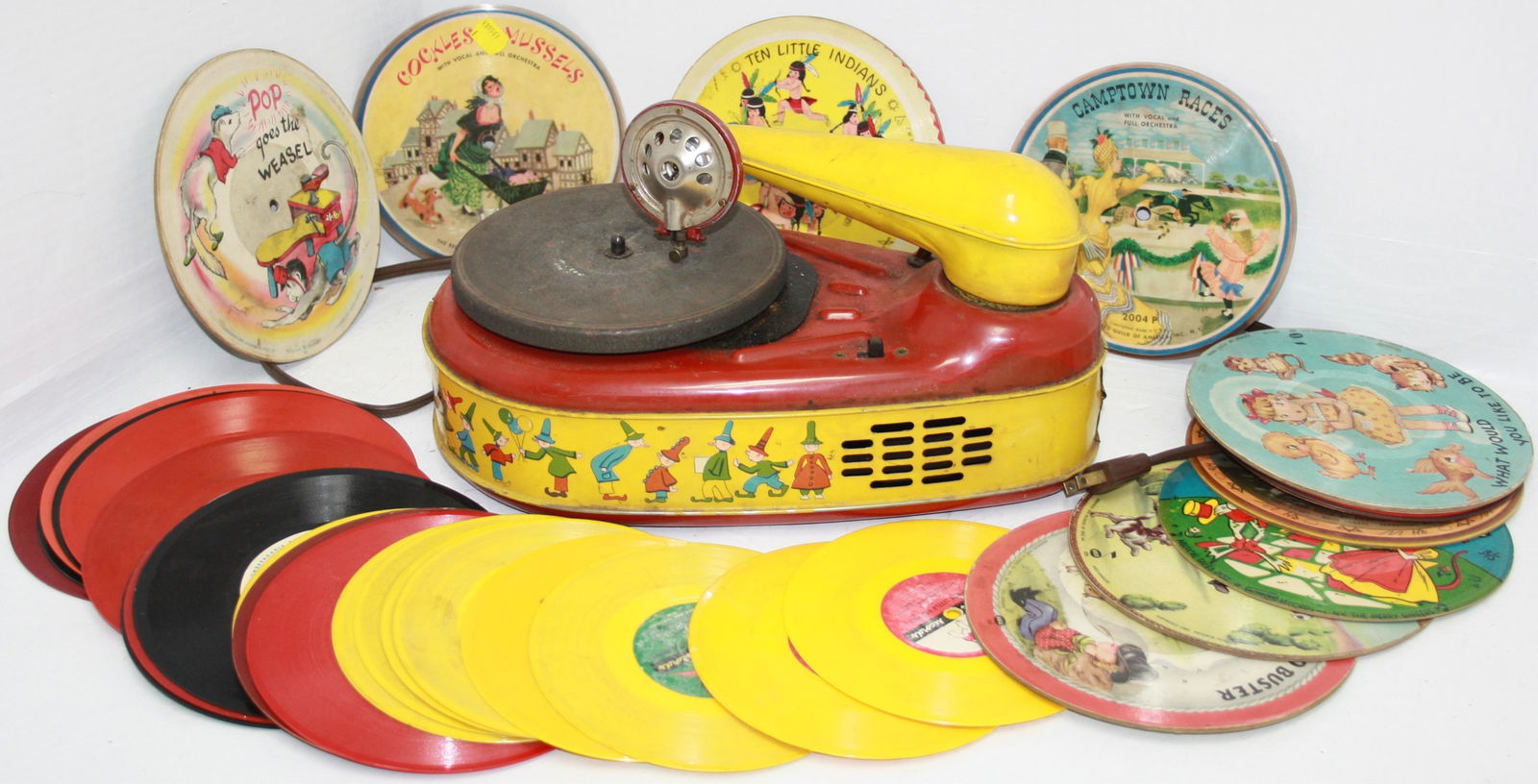 ELECTRIC PHONOGRAPH, MODEL 777, LINDSTROM CORP.,: BRIDGEPORT, CT. TIN LITHOGRAPH DESIGN ON SIDE DEPICTING ELVES. WORKING CONDITION. GOOD ORIGINAL PAINT. 13" LONG, 6 1/2" HIGH, 8" WIDE. ALONG WITH A COLLECTION OF 10 PICTURE RECORDS BY THE RECORD GUILD