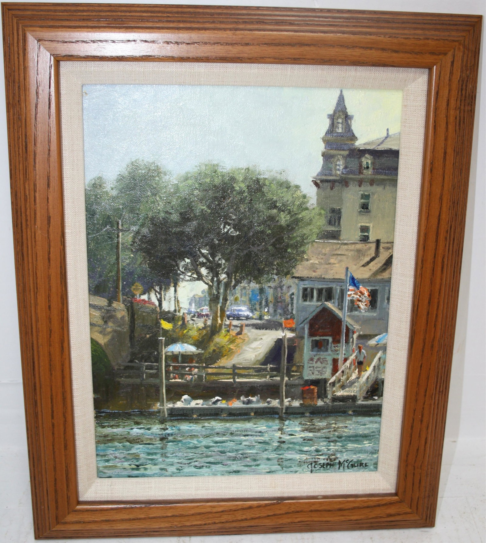 JOSEPH MCGURL (BORN 1958, MA) OIL PAINTING ON: ARTIST'S BOARD, DEPICTING A DOCKSIDE VILLAGE SCENE WITH PEOPLE AND CARS. SIGHT SIZE 11 1/2" X 8", WITH FRAME 15 3/4" X 12 1/2". SIGNED LOWER RIGHT.