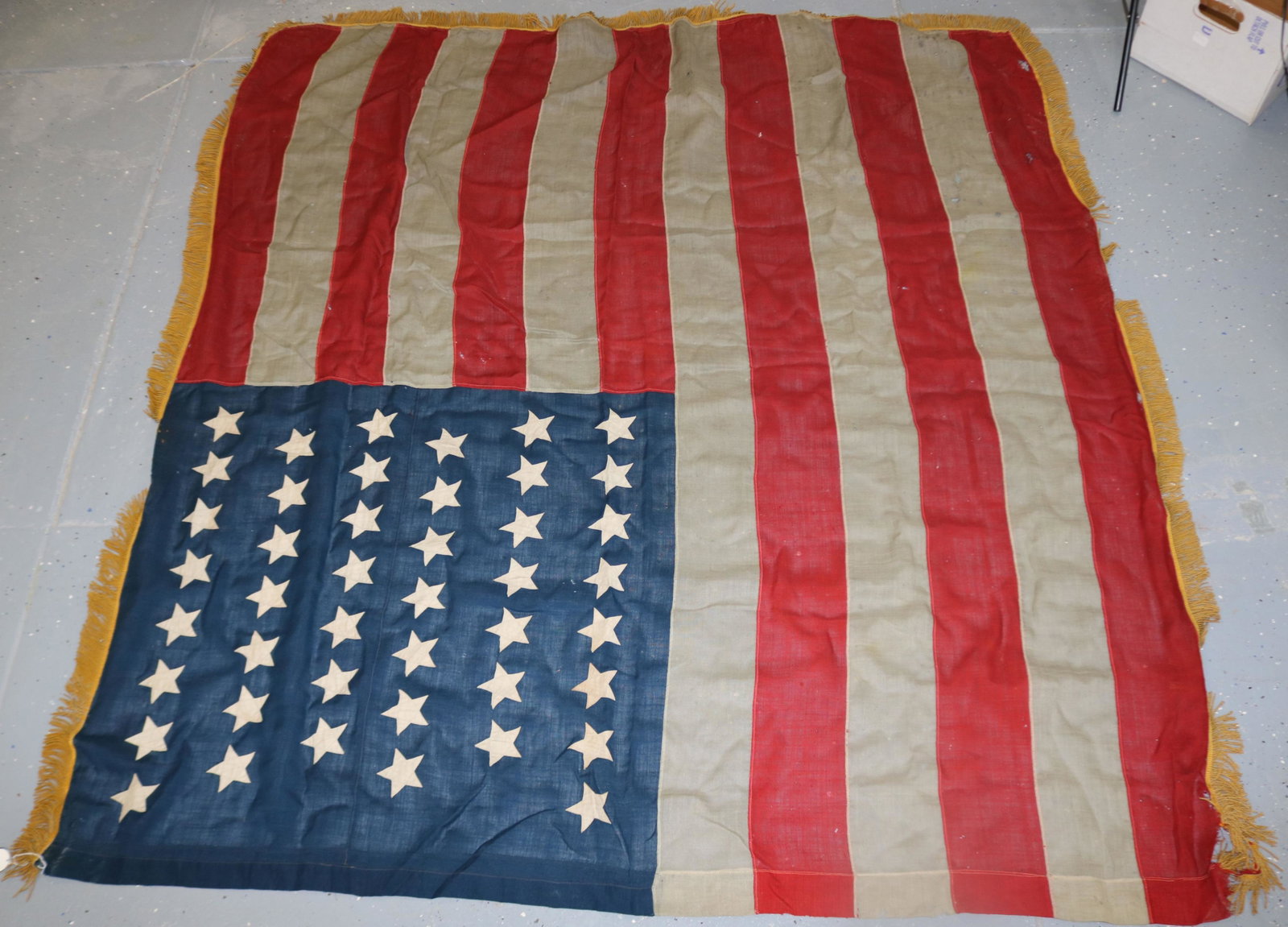 44 STAR AMERICAN FLAG, CA. 1890-1897. UNUSUAL: GOLD FRINGE ON EDGES. THIS FLAG FLEW OVER FORT SPOKANE IN WASHINGTON STATE WHICH WAS ERECTED IN 1890. IT WAS THE LAST FORT BUILT IN THE NORTHWEST TERRITORY DURING THE WESTERN INDIAN WARS. HAS SEVERAL 
