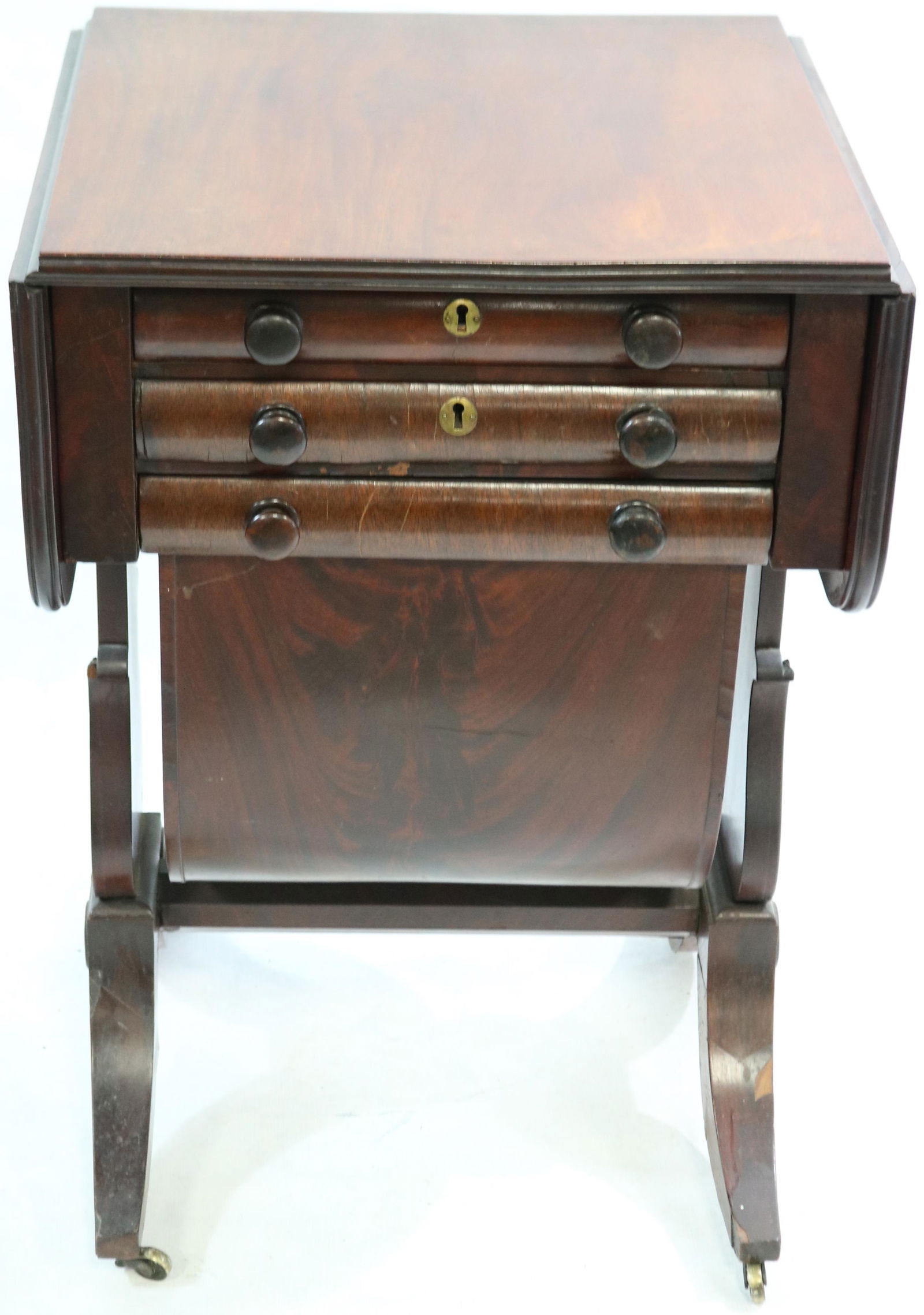 EARLY 19TH CENTURY AMERICAN CLASSICAL MAHOGANY: WORK TABLE/SEWING TABLE. HAS LYRE SHAPED ENDS, UNUSUAL BAG DRAWER, DUNCAN PHYFE STYLE FEET. INTERIOR WRITING SURFACE. SMALL VENEER LOSS TO LEGS. 28 1/4" HIGH, 18" WIDE, 18" DEEP. 9" DROP LEAVES.