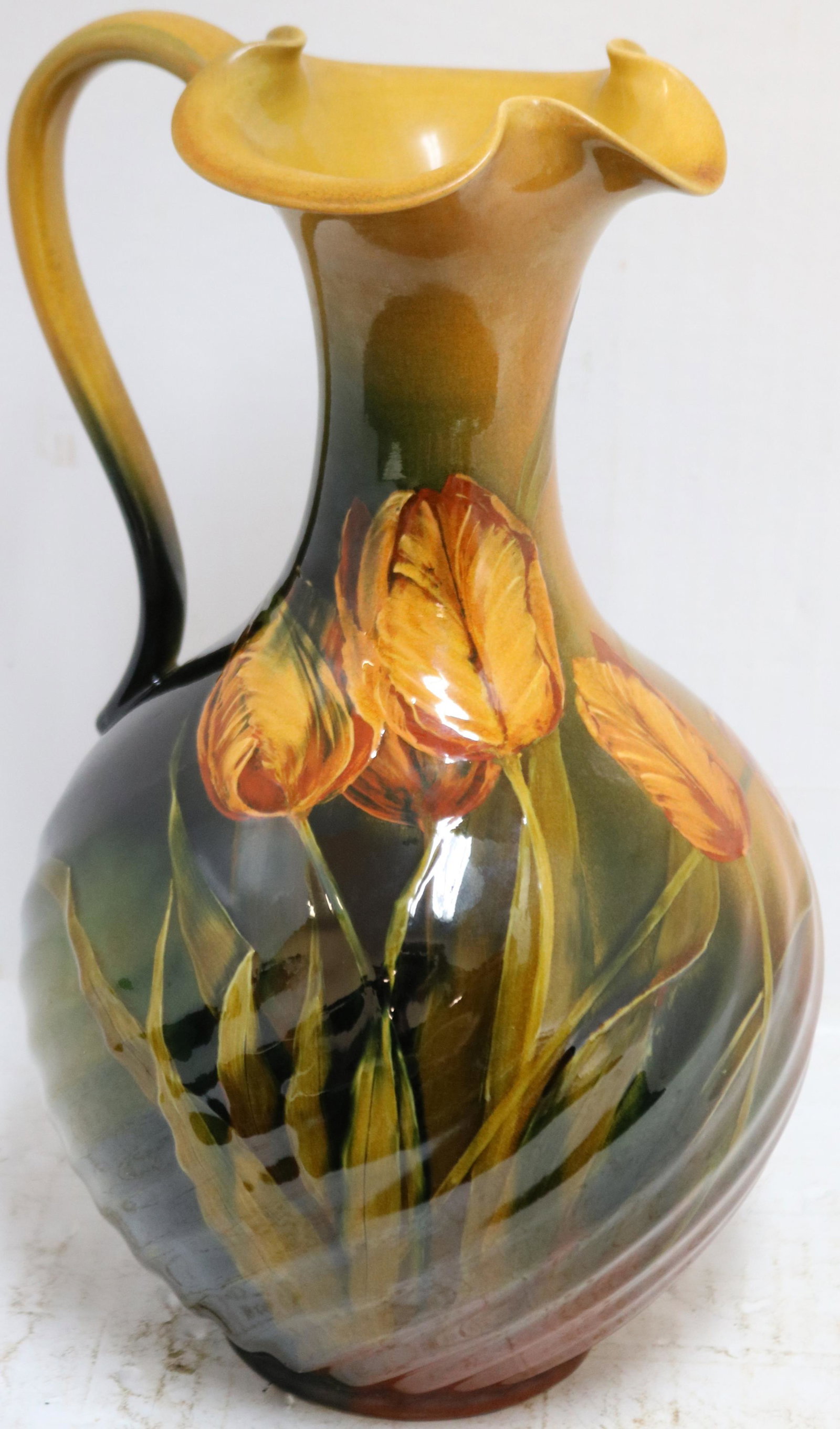 EARLY ROOKWOOD STANDARD GLAZE HANDLED POTTERY: EWER WITH SWIRL BODY AND RUFFLED TULIP DESIGN, SIGNED ON BOTTOM W. P. M. D. (WILLIAM P. MCDONALD), #653W, MADE IN 1892. 13" HIGH, APPROX. 7 1/2" DIAMETER. GOOD ORIGINAL CONDITION.
