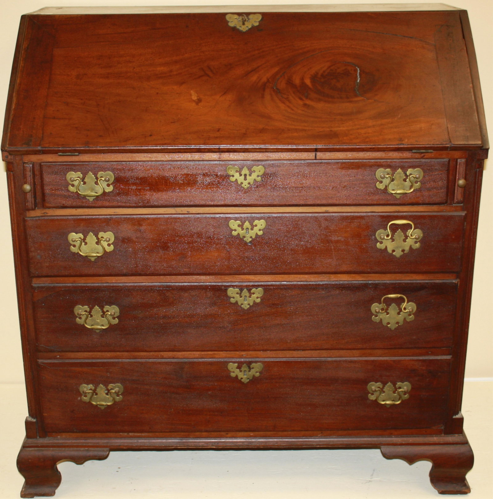 LATE 18TH CENTURY AMERICAN CHIPPENDALE SLANT LID: DESK, OUTSTANDING FIGURED MAHOGANY, PINE SECONDARY WOOD, POSSIBLY INDICATING A BOSTON MAKER. CARVED QUARTER COLUMNS ON EACH SIDE. THREE SECRET DRAWERS HIDDEN BEHIND THE CENTRAL PROSPECT PANEL INSERT. 