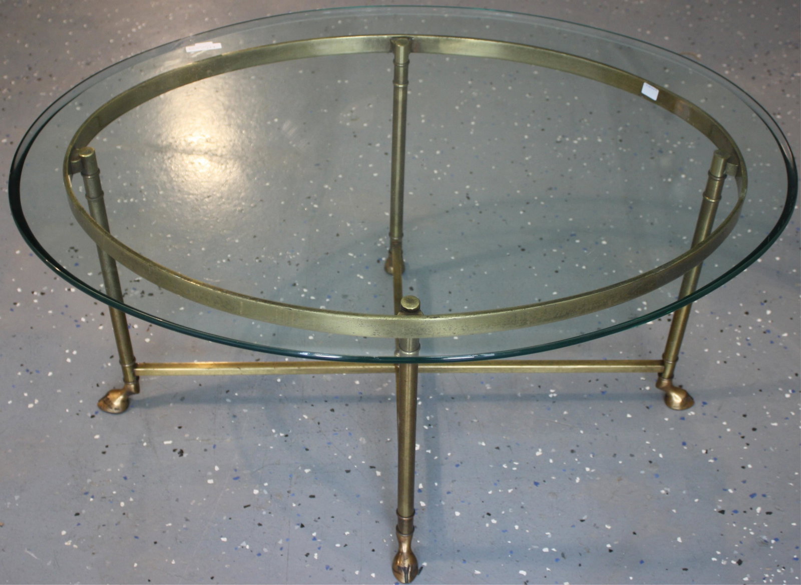 CA. 1970S LABARGE, OVAL GLASS TOP, BRASS BASE: COFFEE TABLE WITH DEER HOOF FOOT. 17" HIGH, 35" WIDE, 26" DEEP.