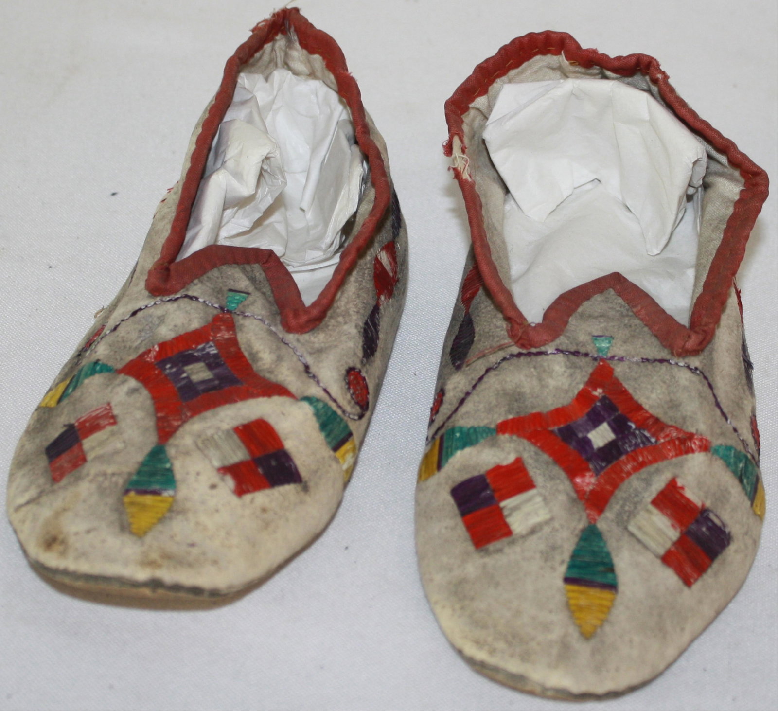 EARLY 20TH CENTURY COLORFUL PORCUPINE QUILL: SLIPPERS. NATIVE AMERICAN, NORTHERN PLAINS. 8 1/2" LONG, 3 1/2" WIDE. OVERALL GOOD CONDITION, SOME LOSS TO QUILL WORK.