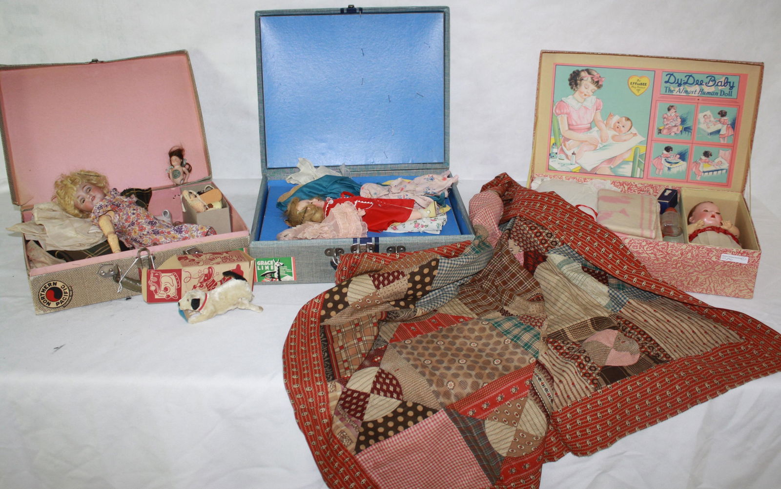 LOT OF THREE MID-20TH CENTURY BOXED DOLLS. TO: INCLUDE: AN EFFANBEE DY-DEE BABY "THE ALMOST HUMAN DOLL", IN ORIGINAL BOX WITH CONTENTS. ALONG WITH A SMALL SUITCASE WITH A COMPOSITION DOLL WITH LARGE COLLECTION OF CLOTHING, 11" LONG. ANOTHER SMALL