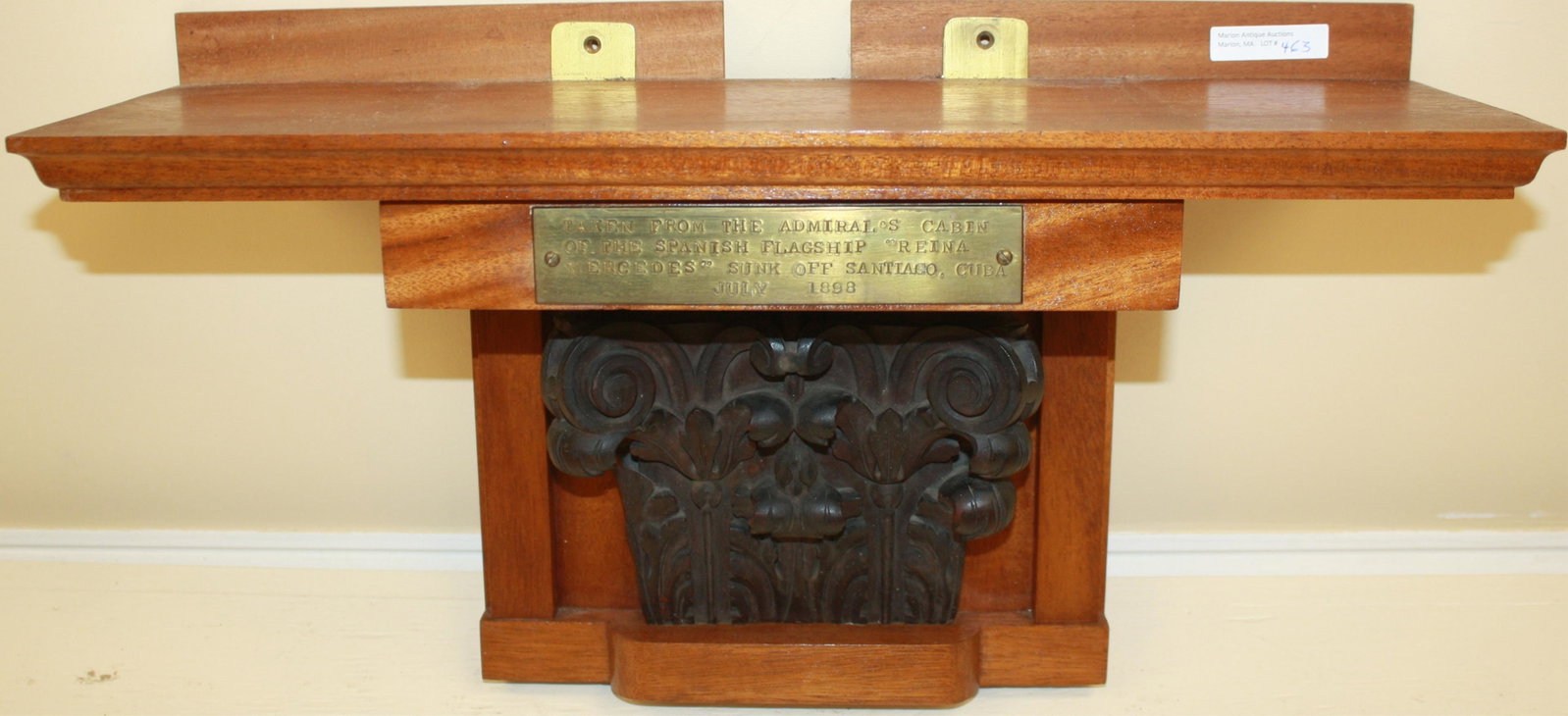 HAND CARVED MAHOGANY CAPITAL, "TAKEN FROM THE: ADMIRAL'S CABIN, OF THE SPANISH FLAGSHIP REINA MERCEDES, SUNK OFF SANTIAGO, CUBA, JULY 1898". HAS SINCE BEEN CONVERTED INTO A WALL BRACKET. 10 1/2" HIGH, 19" WIDE, 6 1/2" DEEP.