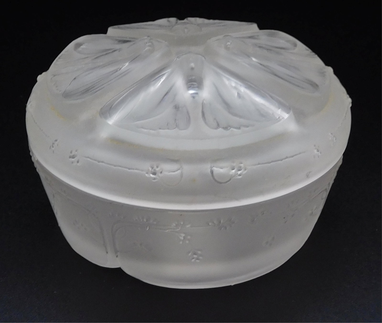 Renee Lalique (1860-1945, French) frosted glass: powder jar, Quatre Papillon pattern. Nick on outer rim. Block letter signature on base. 3" diameter, 1 3/4" tall.
