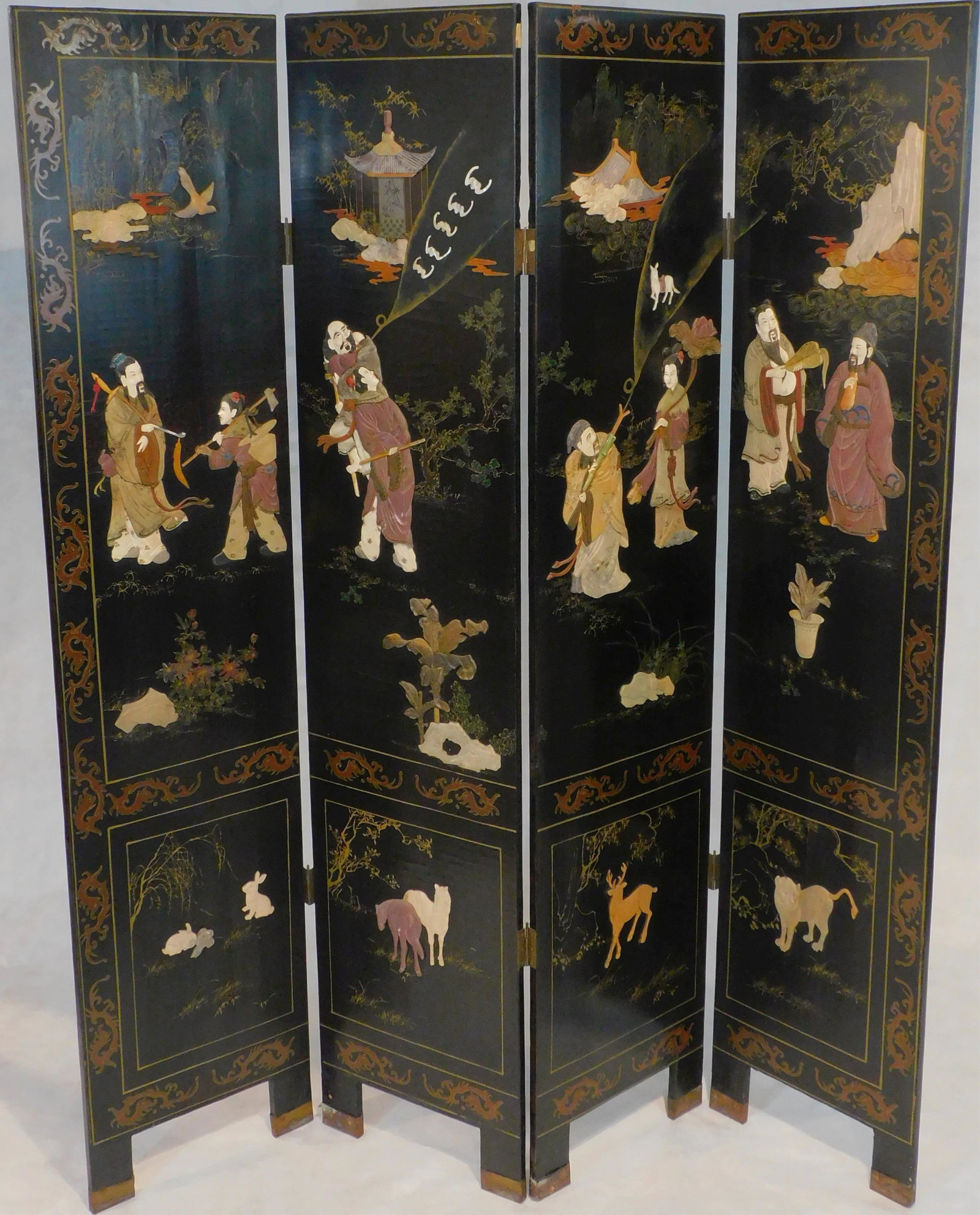Early 20th century four-fold oriental lacquered screen: with carved hardstone figures, plants, and animals. 72" high, 64 1/2" wide. Minor loss to hardstone, some craquelure.