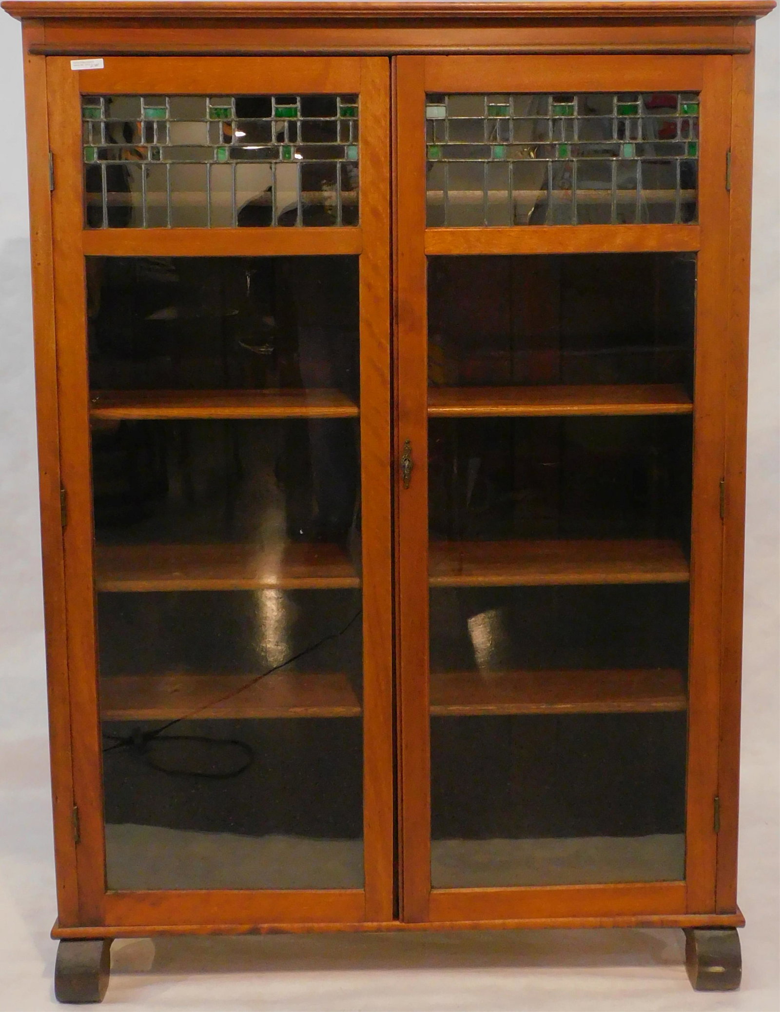 Arts and Crafts Larkin bookcase, ca. 1910. Leaded: glass top panel doors, maple. Larkin label on back, four interior shelves. Excellent condition. Scroll feet. Comes with a key. 57 1/2" high, 42" wide, 13 3/4" deep.
