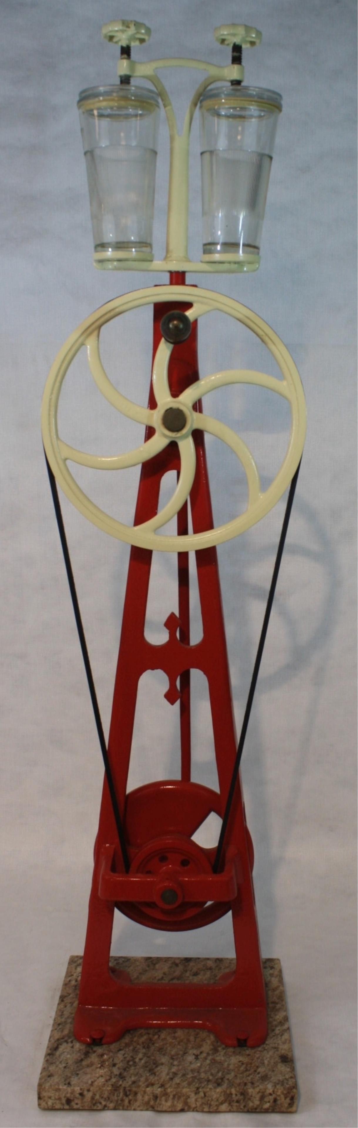 Restored cast iron manual country store milkshake: maker on a marble base. Early 20th century Two Hazel Atlas glasses with later lids. Belt driven. 49 1/2" high, 12" wide, 12" deep.