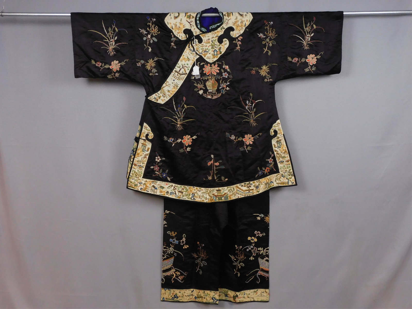 Asian robe and trousers set, probably Chinese: made for Western export. Black silk ground with multicolored and gold hand embroidery. Early 20th century. The main motifs are of flowers, some of which are in vases, or on tables. Trimmed with hand e
