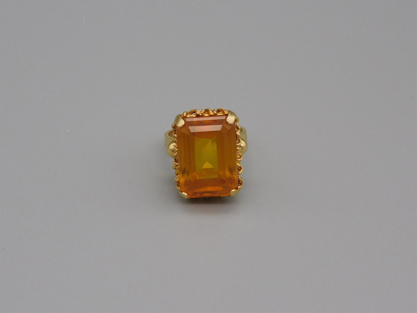 18kt yellow gold lady's ring, set with large: emerald cut topaz. Size 5. Stone is approximately 5/8" x 1/2". 6.4 total dwt.