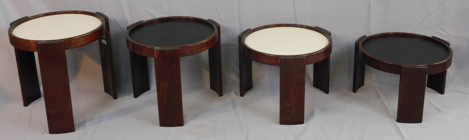 Gianfranco Frattini (1926-2004), for Cassina,: model 780 nesting tables, rosewood with reversible laminate tops, all with the original Cassina labels, made in Italy, 1966. Tallest measures 15 1/4" high, lowest 9 1/2" high. All have 15 1/2" diamete