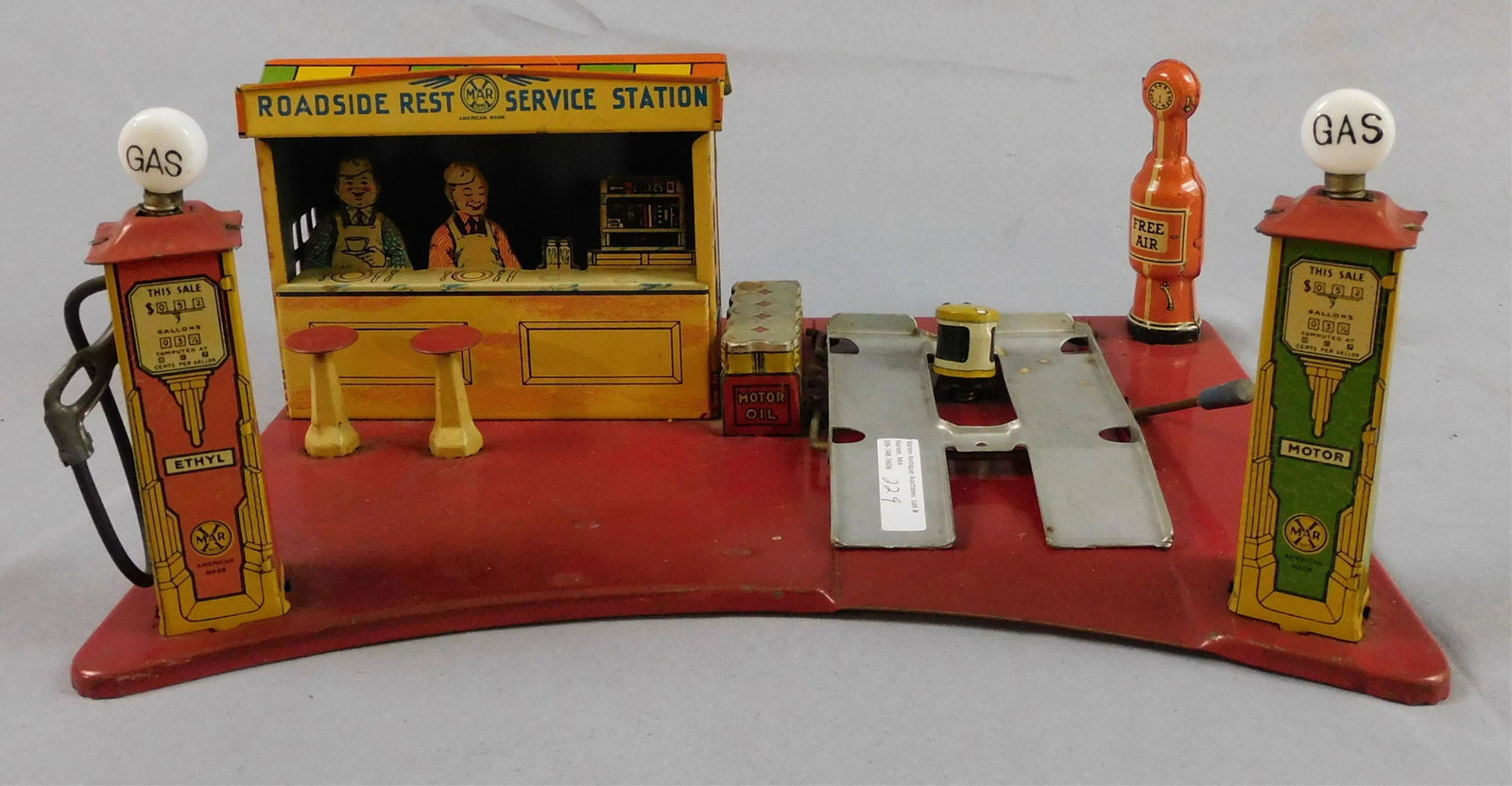 Marx Roadside Restaurant service station, litho: tin. Early 20th c. Working car lift, glass lenses and bulbs on the pumps. Battery operated lights. Overall good original condition. 13 3/4" wide, 10 1/2" deep, 5 1/4" high at the tallest point. Both g
