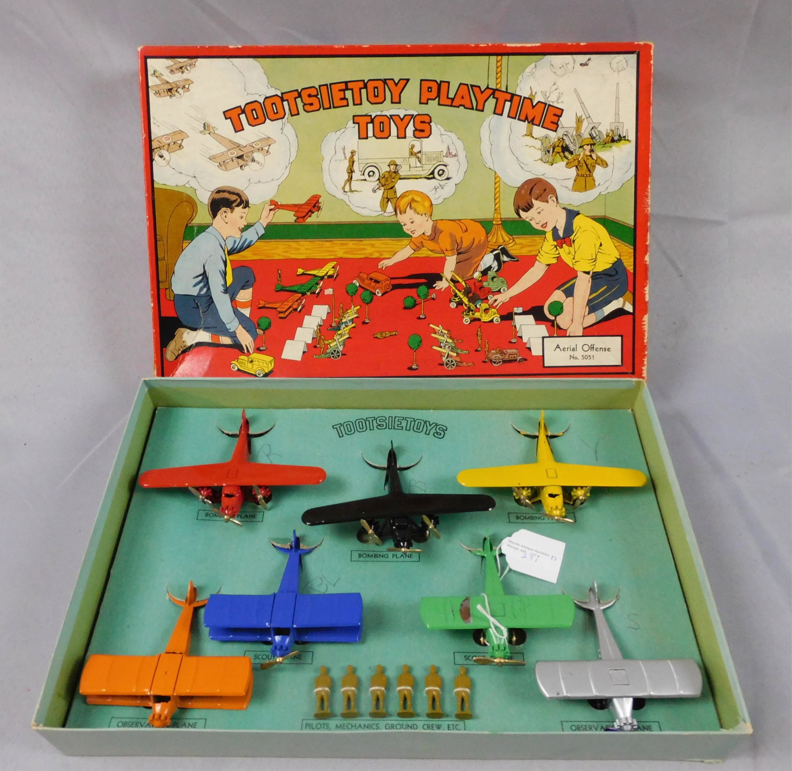 Tootsietoy Playtime airport set, Aerial Offense: #5051. Ca. 1940s. Great original colored lithograph box opens to reveal seven WWI era fighter planes and six figures of pilots, mechanics, and ground crew. Very good original condition, green scout pl