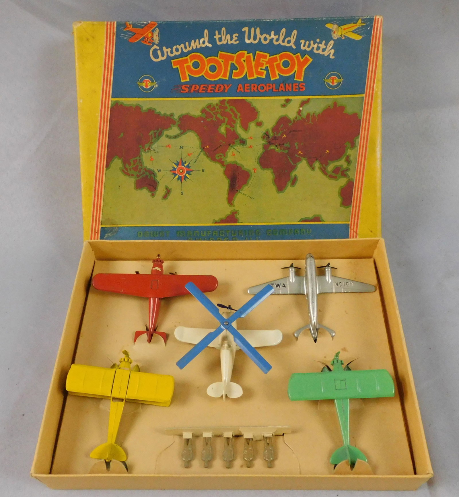 Tootsietoy Around the World Speedy Aeroplanes,: ca. 1930s. Original colored lithograph box. Dowst Manufacturing Co., Chicago. Box contains 5 airplanes, and 5 mechanics. Excellent original condition, near mint. Airplanes are each approximately 4" lo