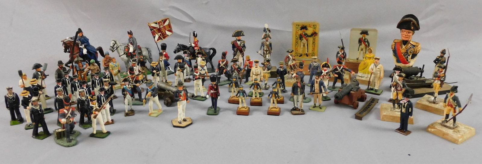 Approximately 87 Britons lead soldier figures,: plus 3 cannons. Two figures encased in. Most figures related to the English Navy and Lord Nelson and the battle of Trafalgar. All 20th c. Most are Britons, etc. One woman in a French court dress. Over
