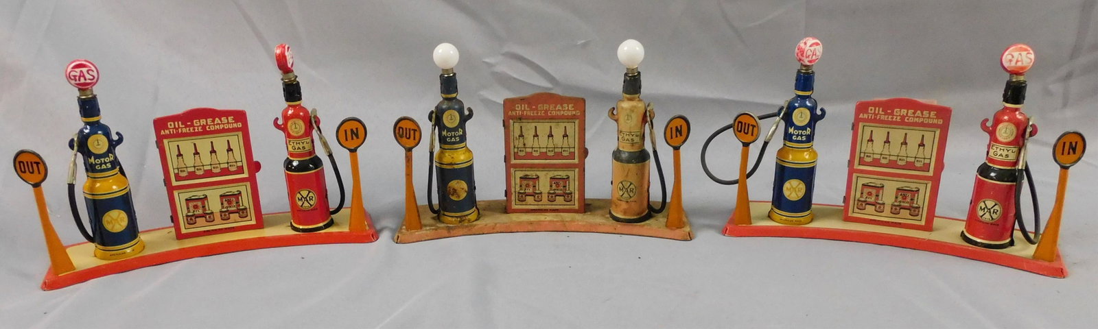 (4) Marx litho tin gas pumps. Ca. 1930s. To: include two in excellent condition, one with worn finish. Two with gas light bulbs and another with plain bulbs. Approximately 6" high, 9" wide, 3 1/2" deep.